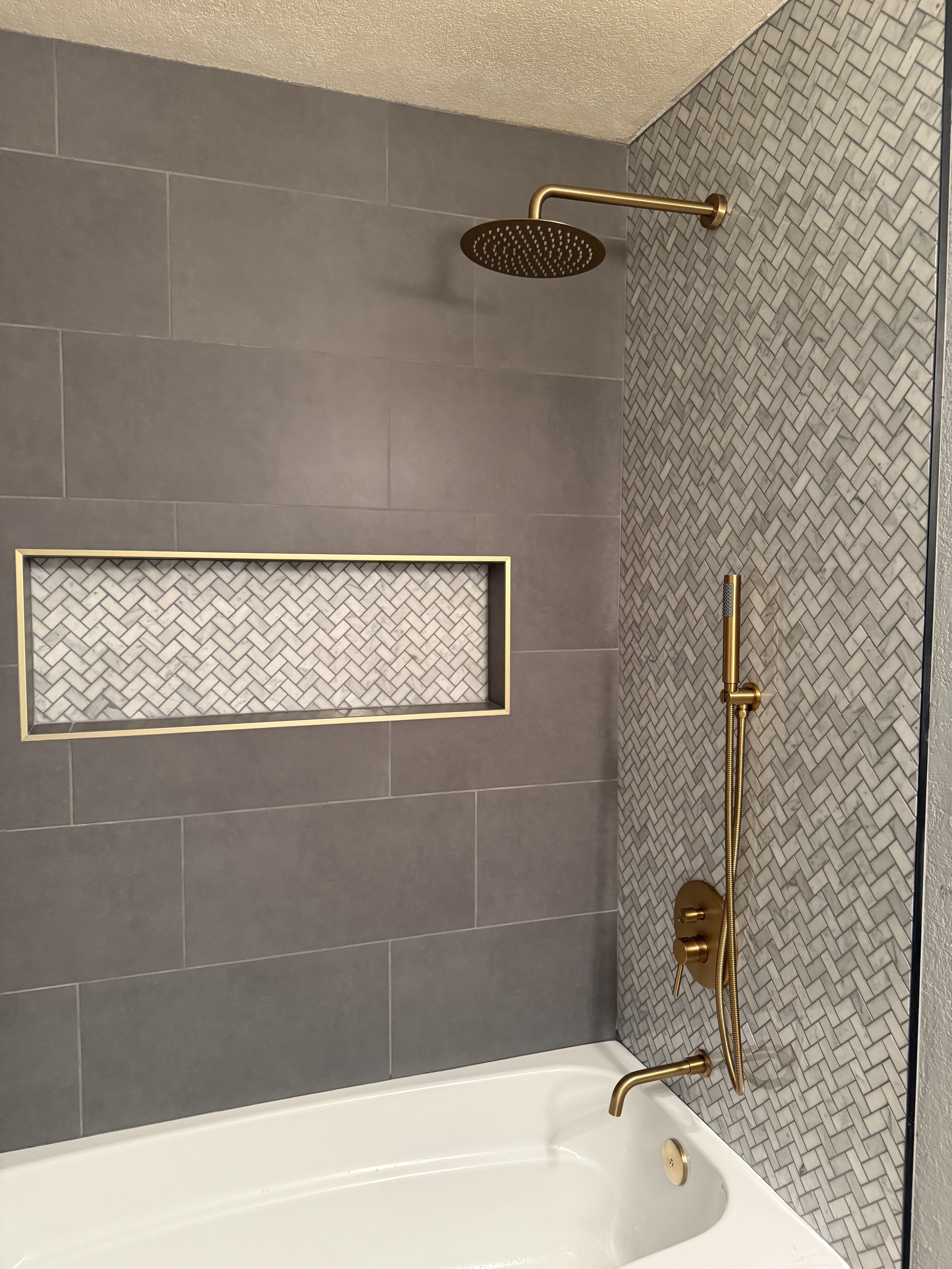 Luxurious bathroom vanity area with a dramatic wall featuring large format natural stone tiles in varying earthy tones and complex veining, serving as a striking backsplash above a double sink vanity.