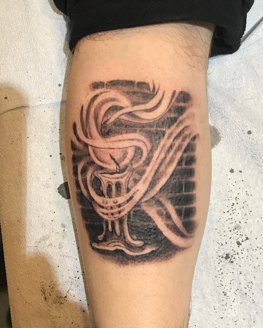 Black-and-grey bird tattoo on a lower leg