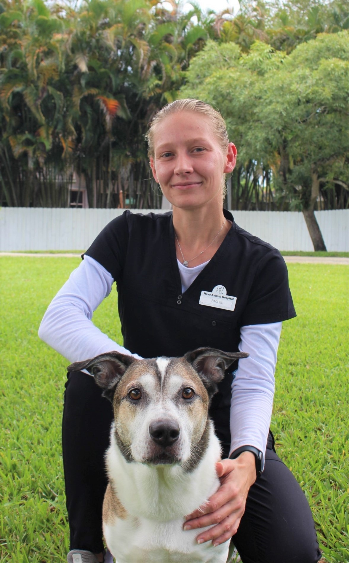 rachel kneeling on the grass with a large mix breed
