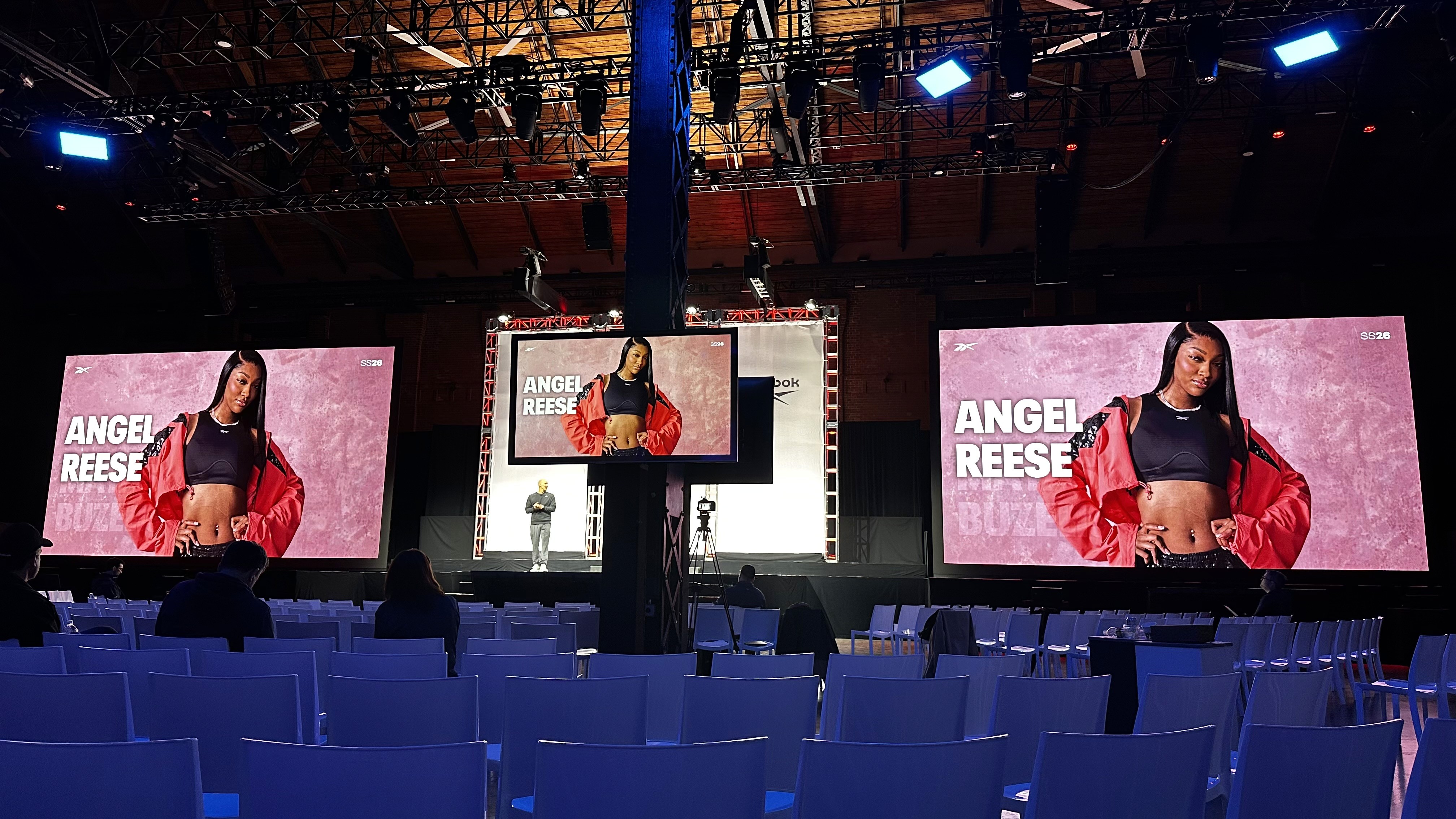 Panel discussion screens featuring a guest speaker at a brand activation stage