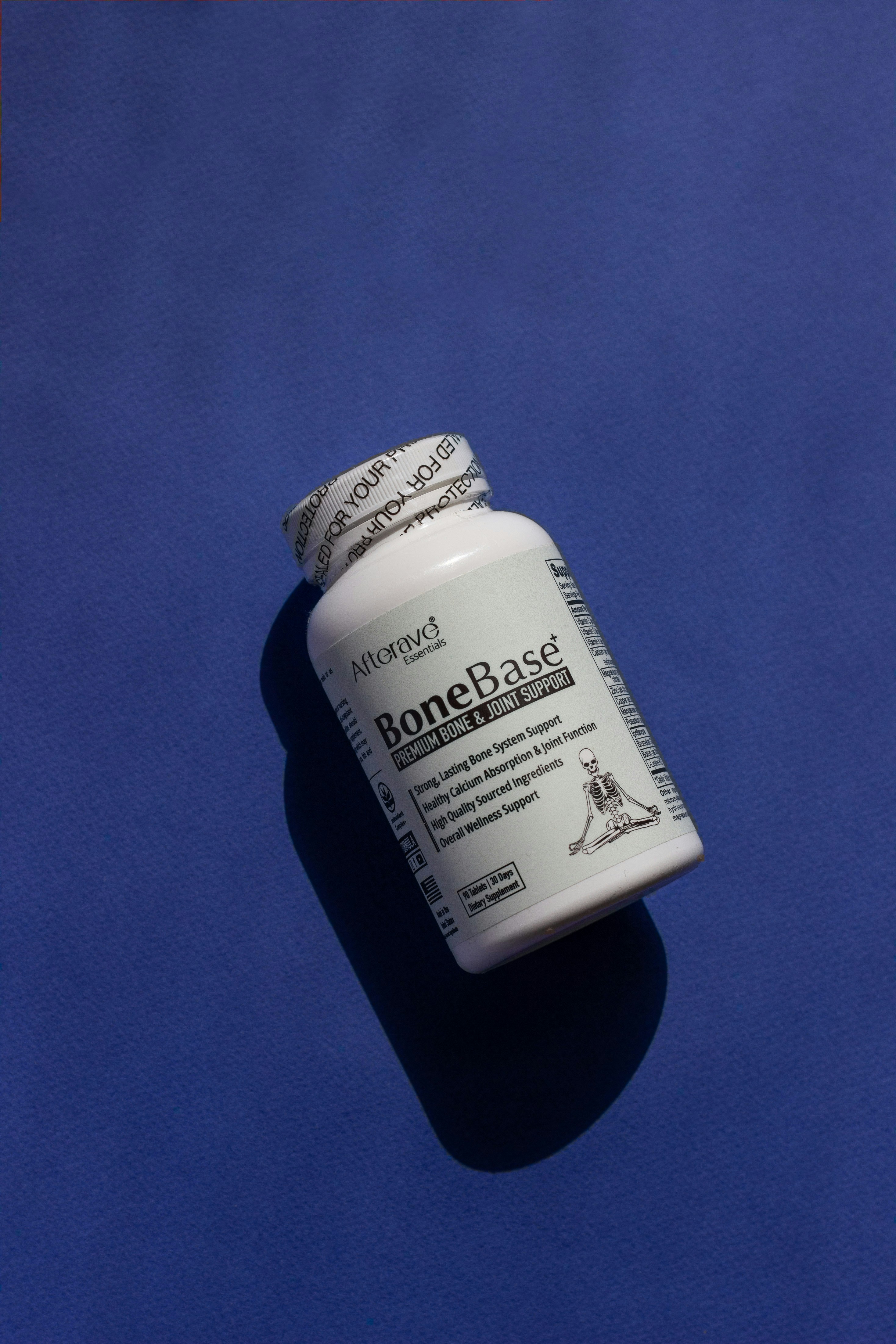 A close up of a pill bottle on a blue surface