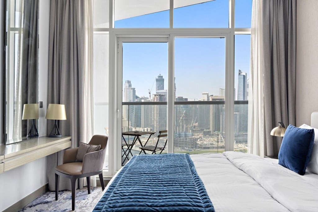 Spacious living room with a large bed and flat-screen TV, part of the Damac Maison Prive accommodations.
