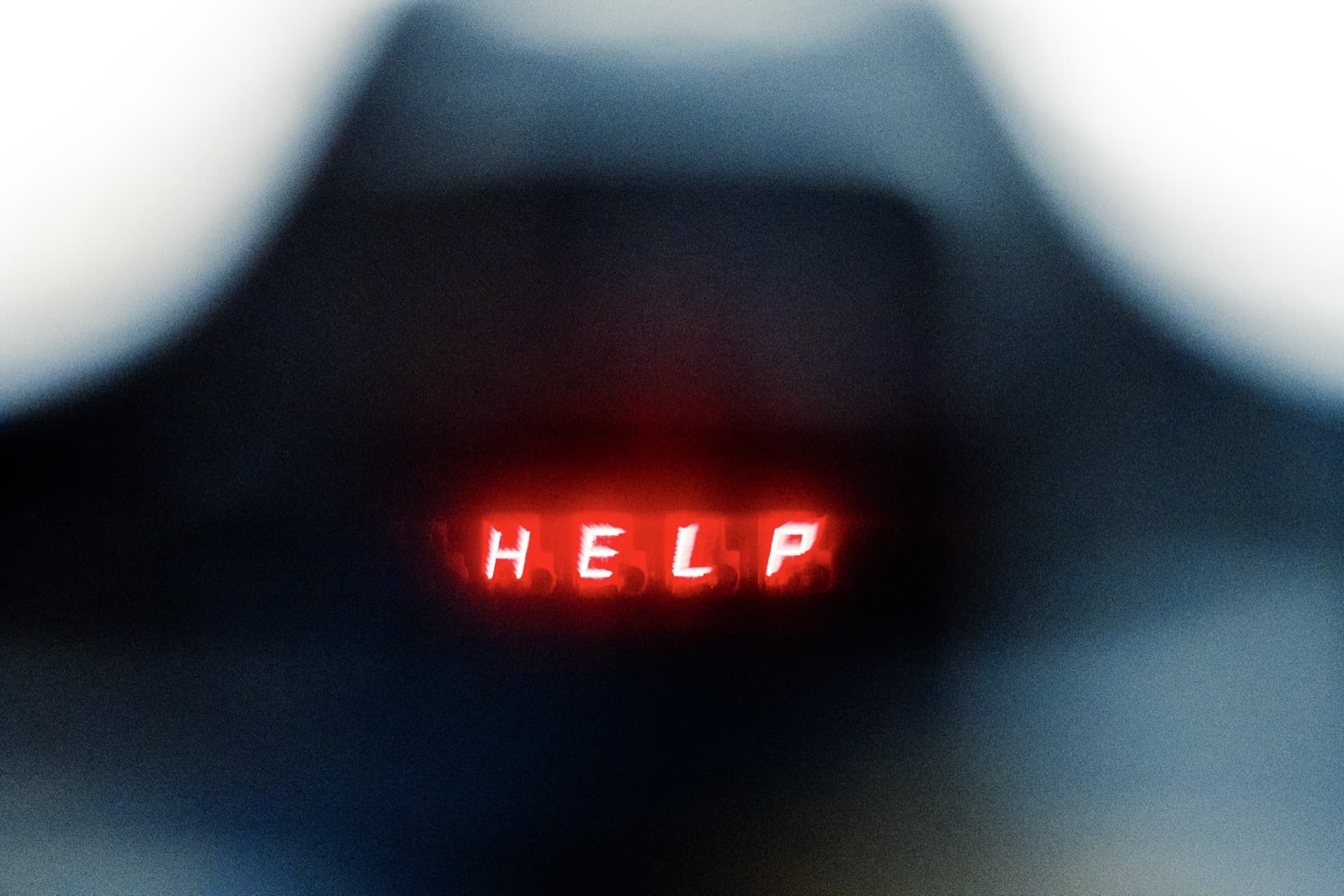 Red illuminated "HELP" error message displayed in Canon T90 viewfinder, bright LED text against dark viewfinder frame with soft vignetting at edges