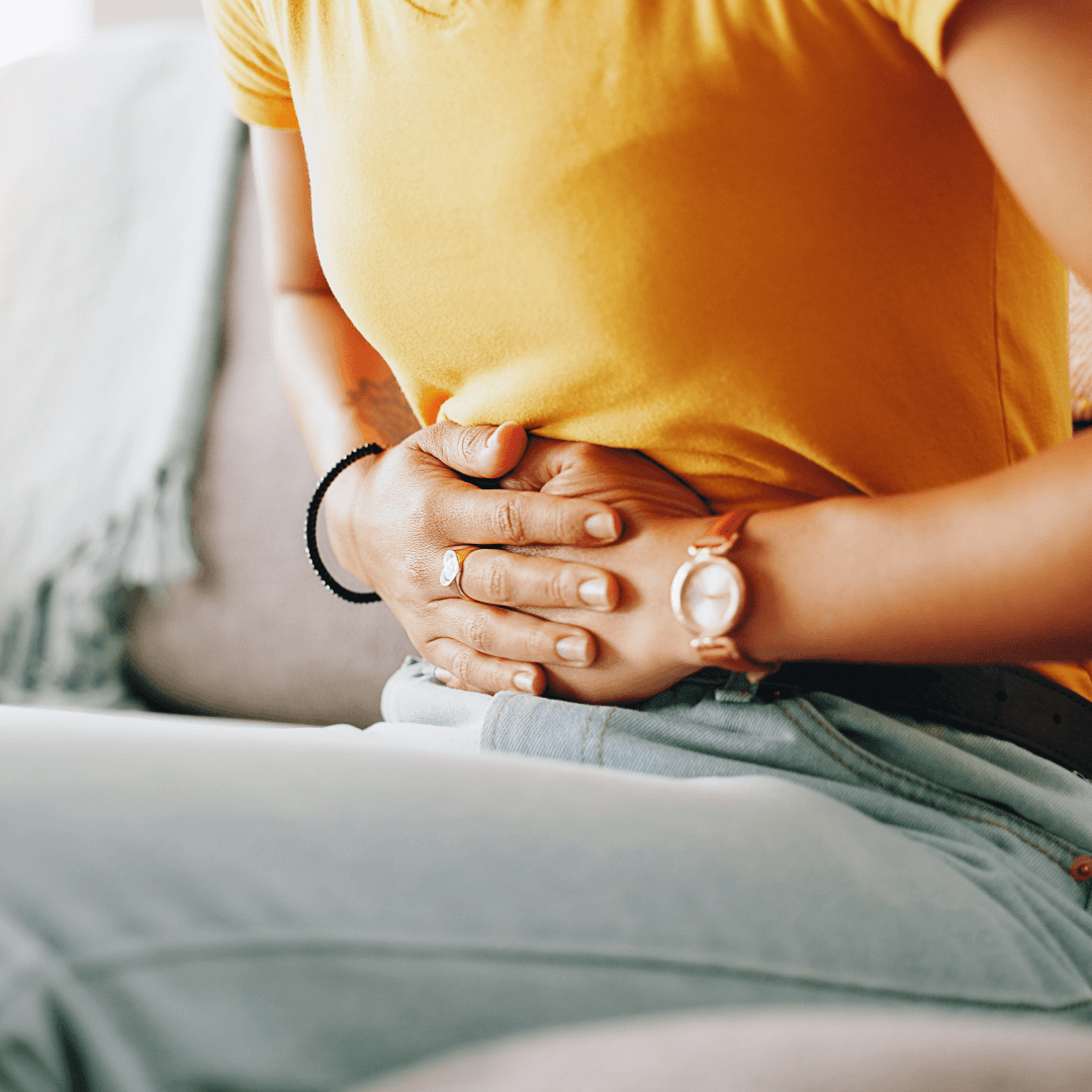a woman holding her stomach beacuase she is bloating