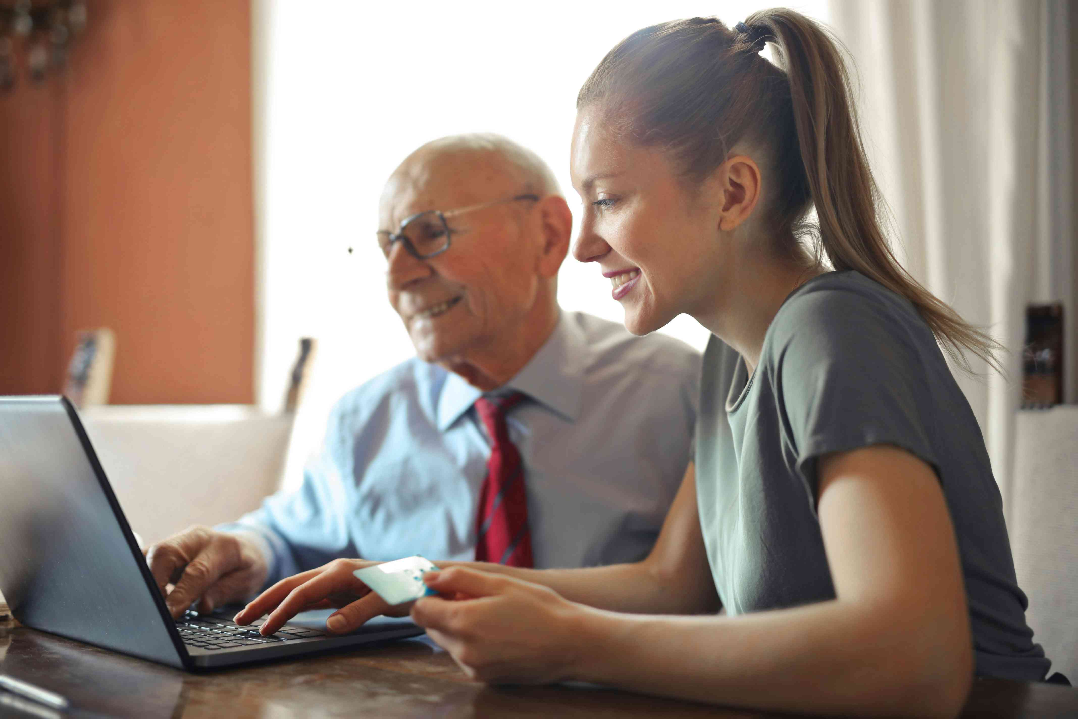 young woman and older man exploring ecommerce on a laptop