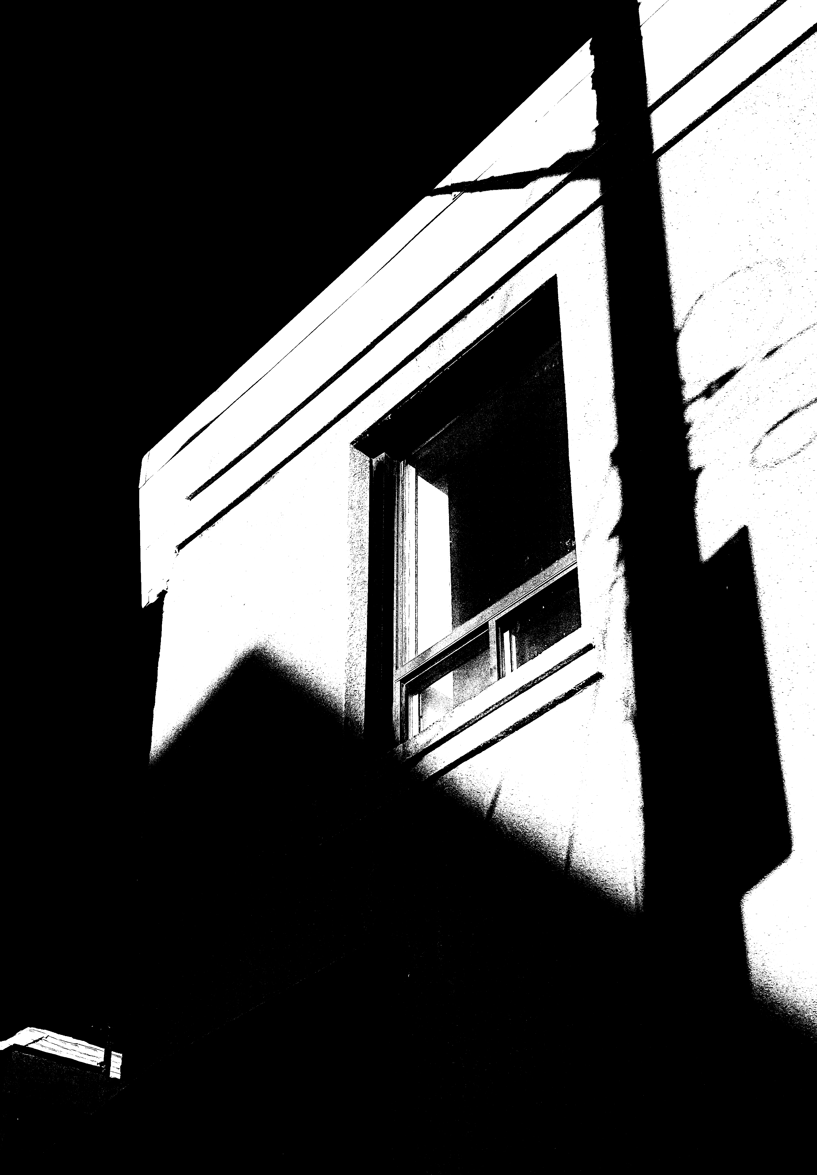 Shadows play on a building's exterior with a window.