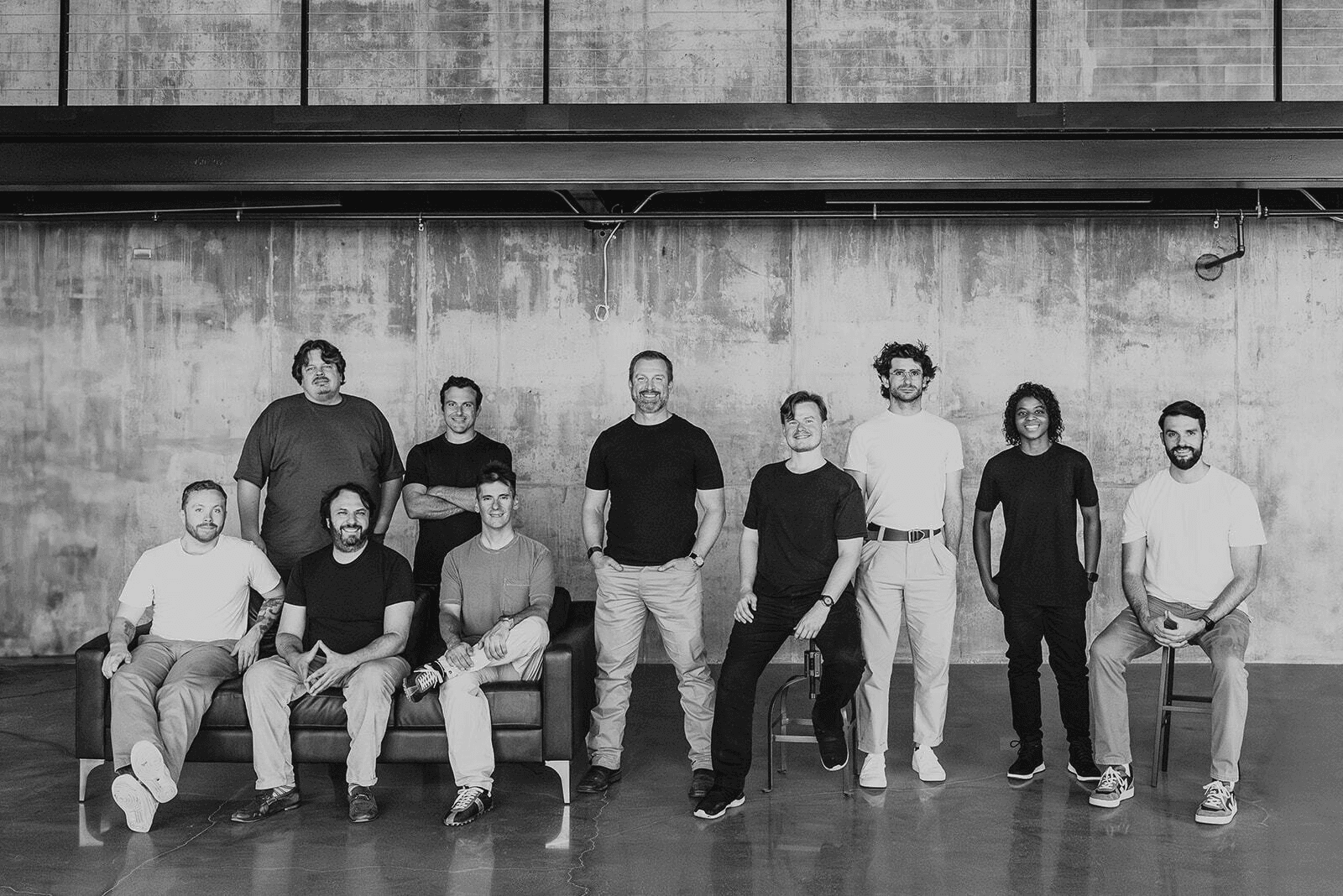 Collaborative work session overhead view of six people collaborating at a rustic wooden table with coffee, papers, and a laptop