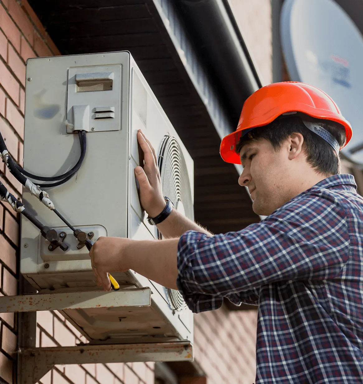 Technicien vérifiant un système de chauffage résidentiel lors d’un entretien préventif.