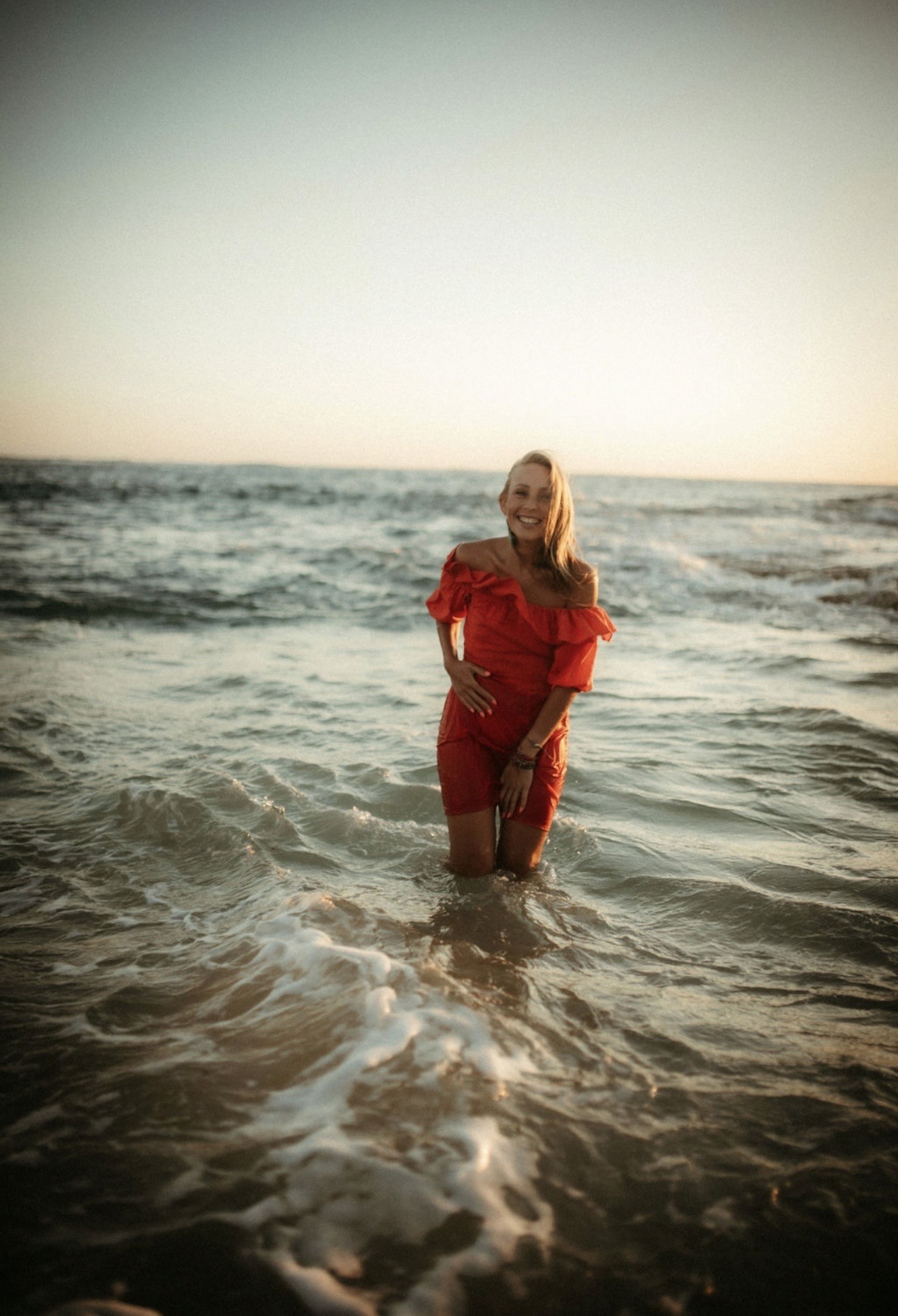 Polina standing in the ocean at sunset