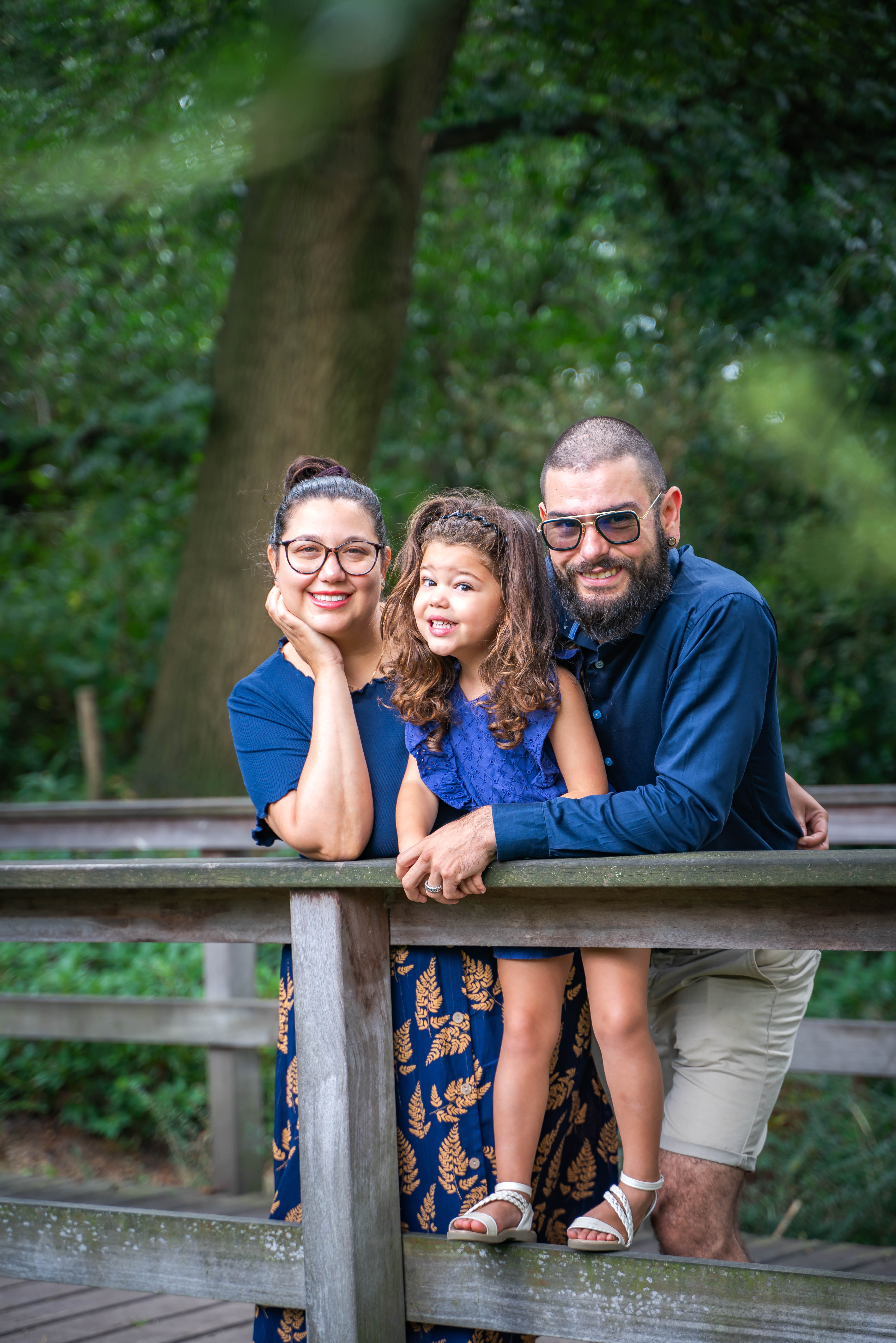 A couple in wedding attire walks hand in hand across a sunlit field.