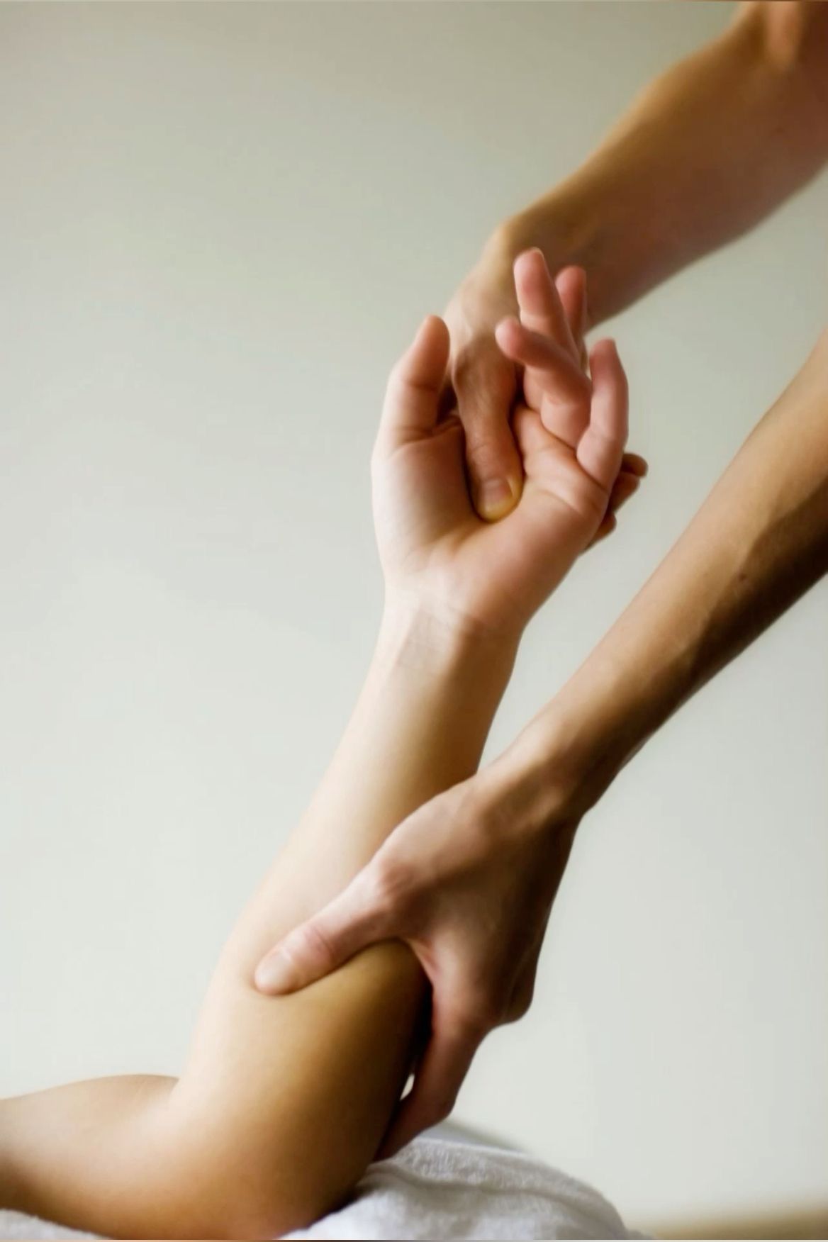 Physiotherapist performing manual wrist and elbow mobilization therapy.