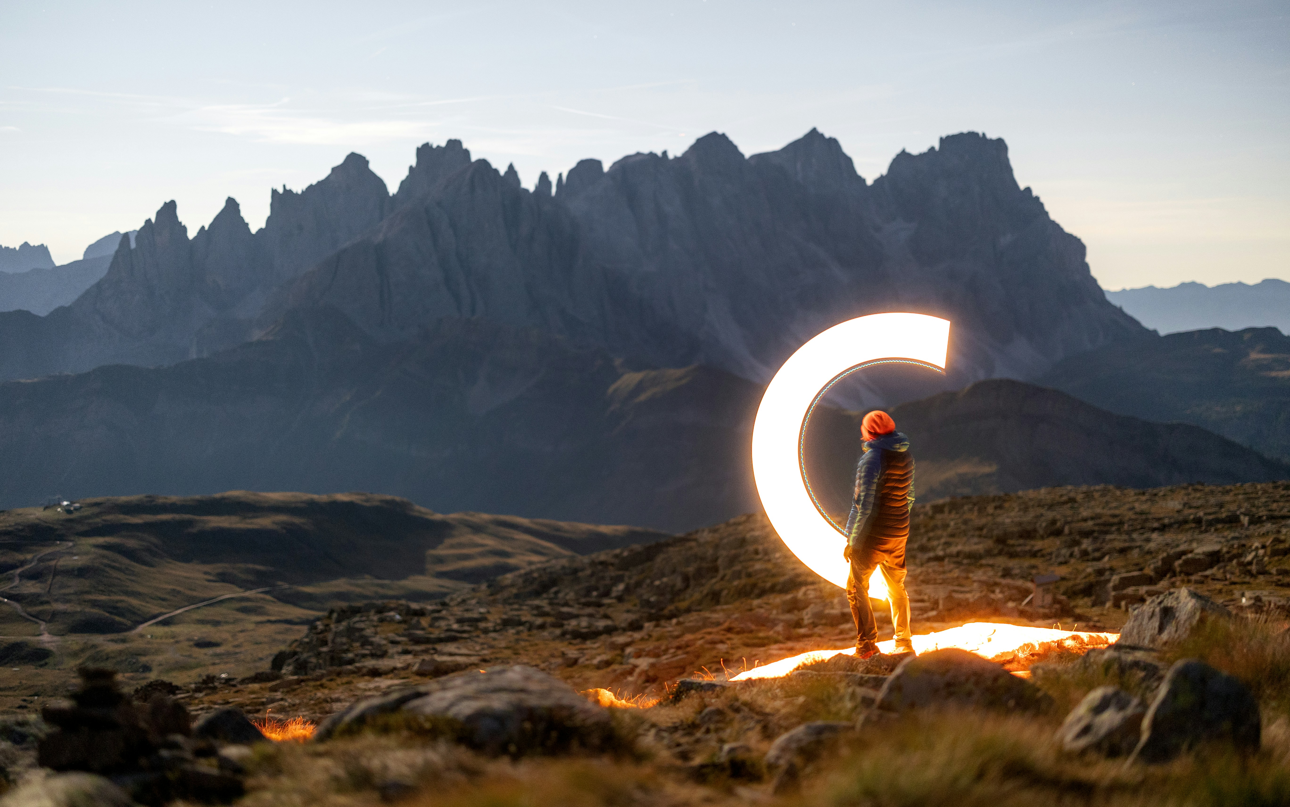 Person with light painting in a mountain landscape.