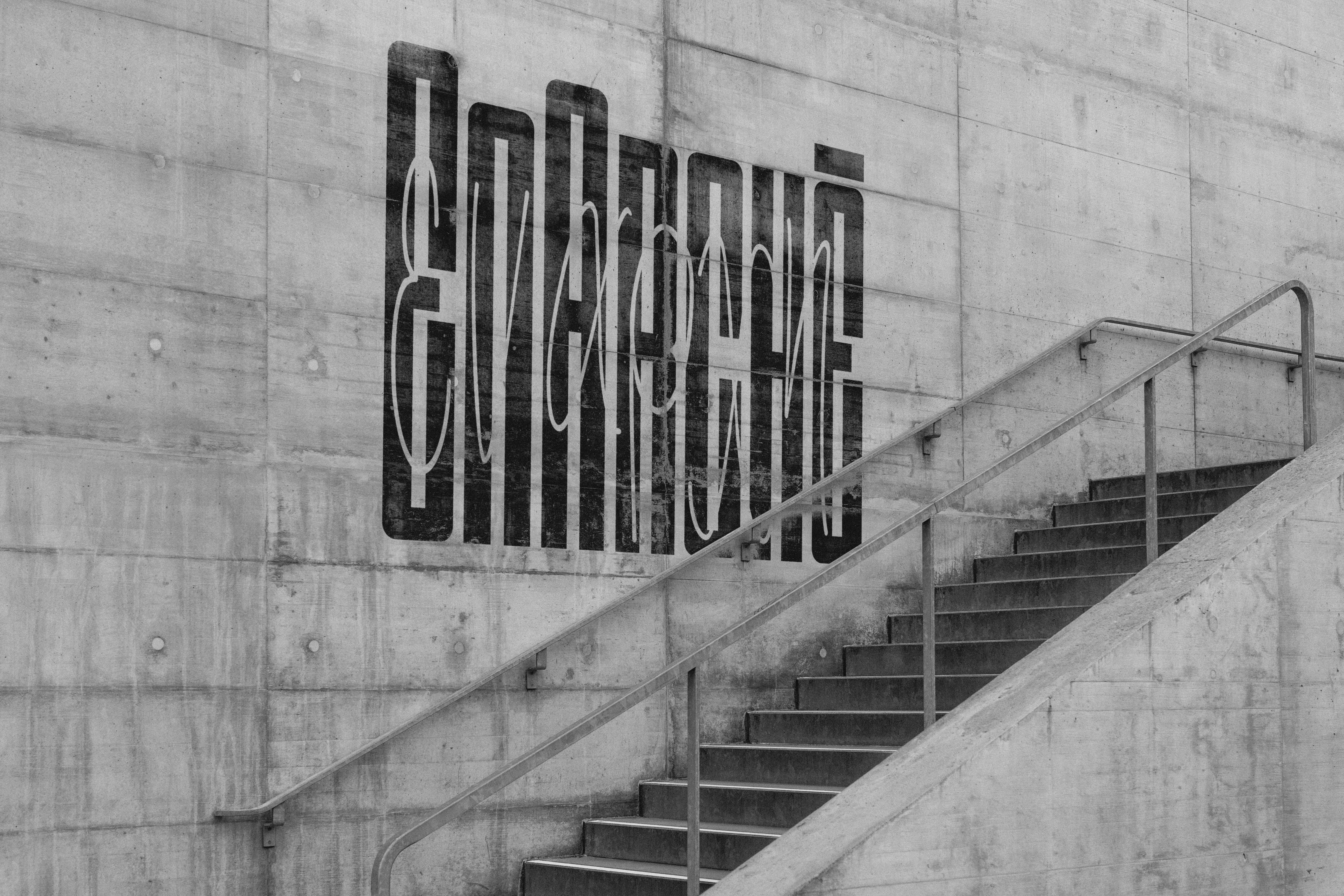Concrete staircase with EnArchē's logo painted on the wall.