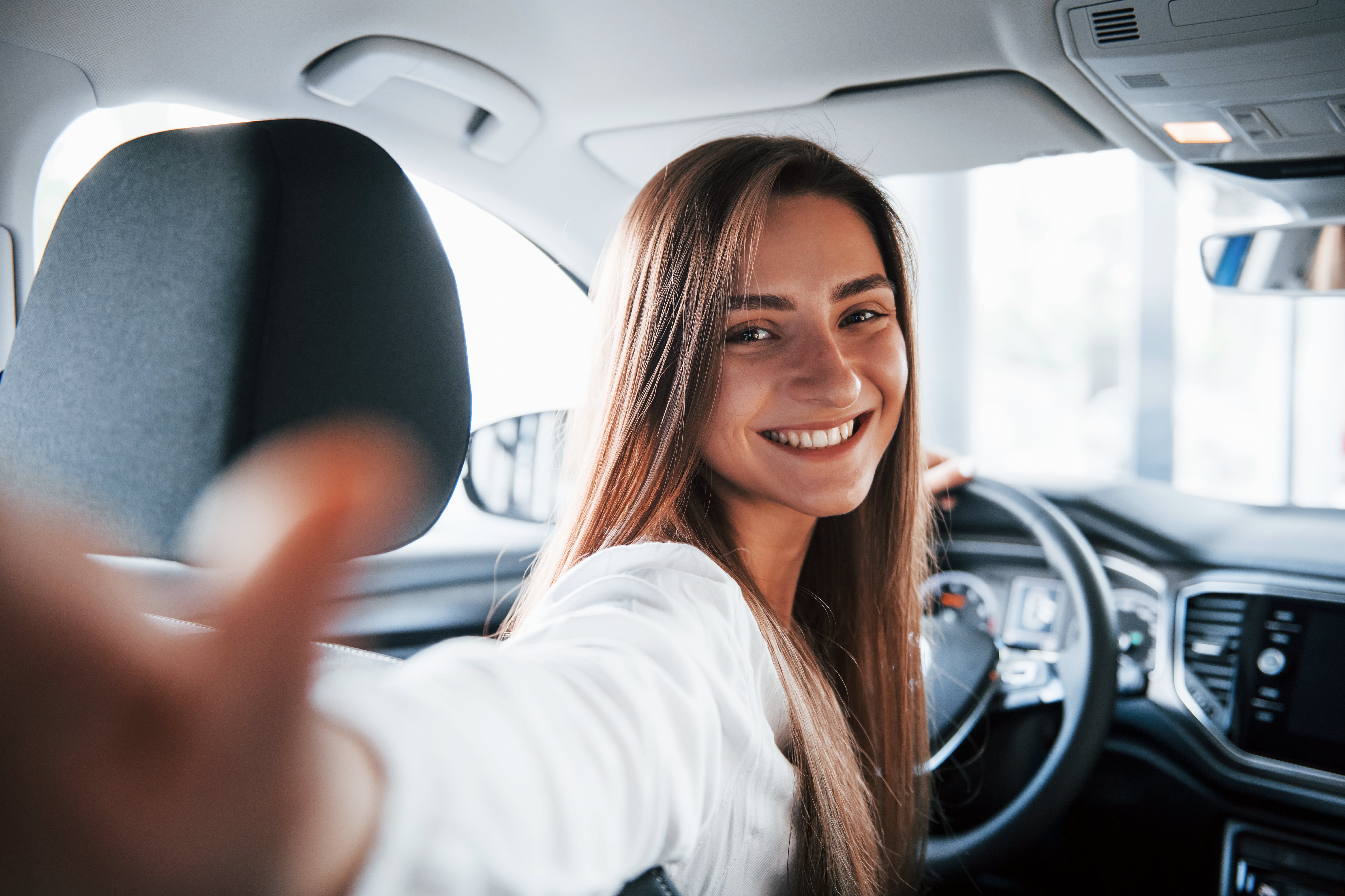 Zufriedene Frau nach erfolgreicher MPU-Vorbereitung sitzt lächelnd im Auto – selbstbewusst und sicher dank professioneller MPU-Beratung und Online-Coaching.