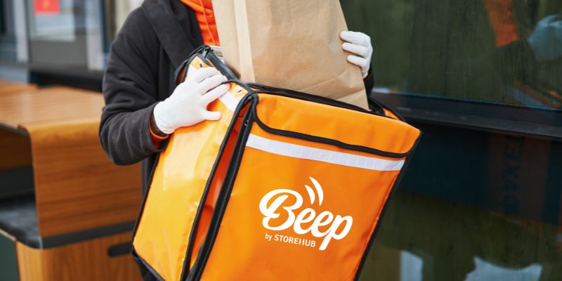 Pemandu motosikal menyimpan makanan dalam begnya.