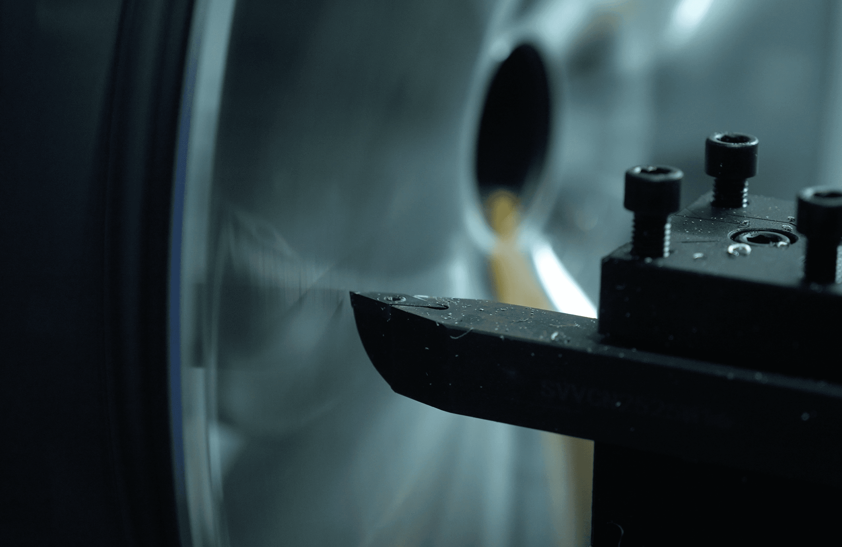 A modern house with large windows and a flat roof, surrounded by greenery against a clear blue sky.