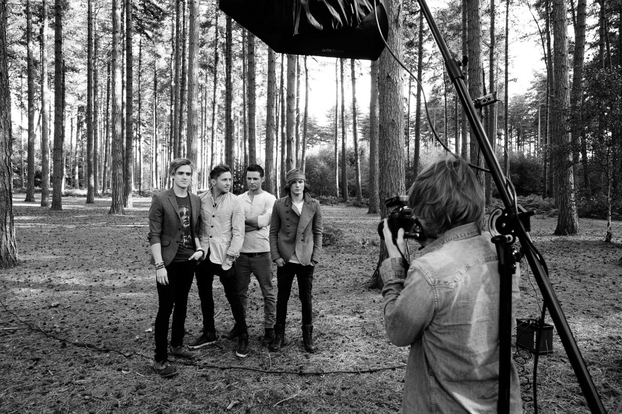 Tom photographing all four McFly members in a forest