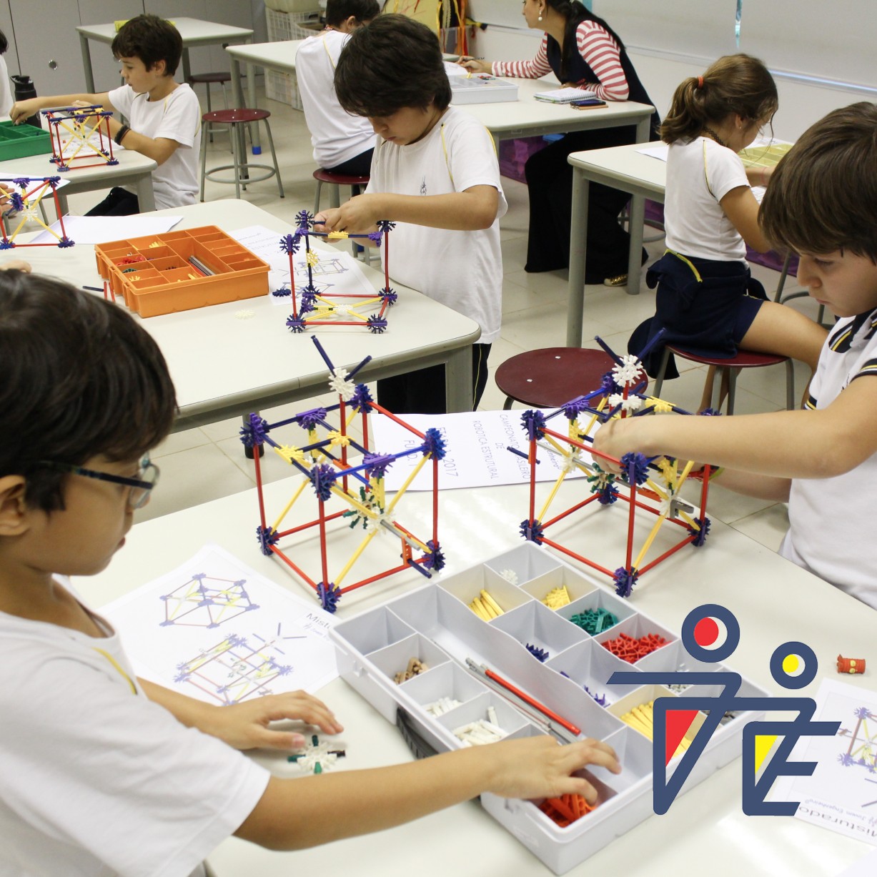 Crianças em sala de aula abrendendo robótica