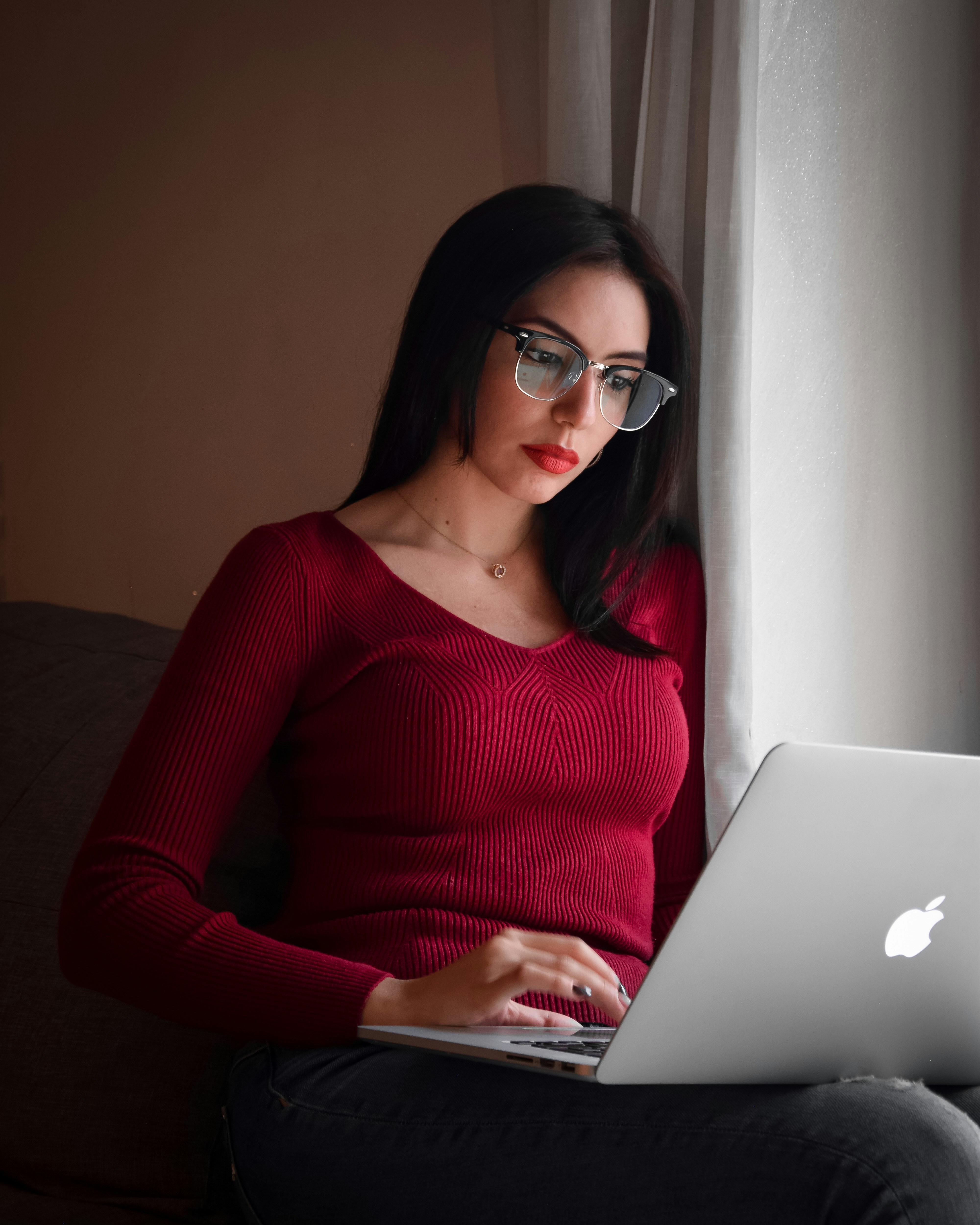 A woman sitting on a couch using a laptop computer