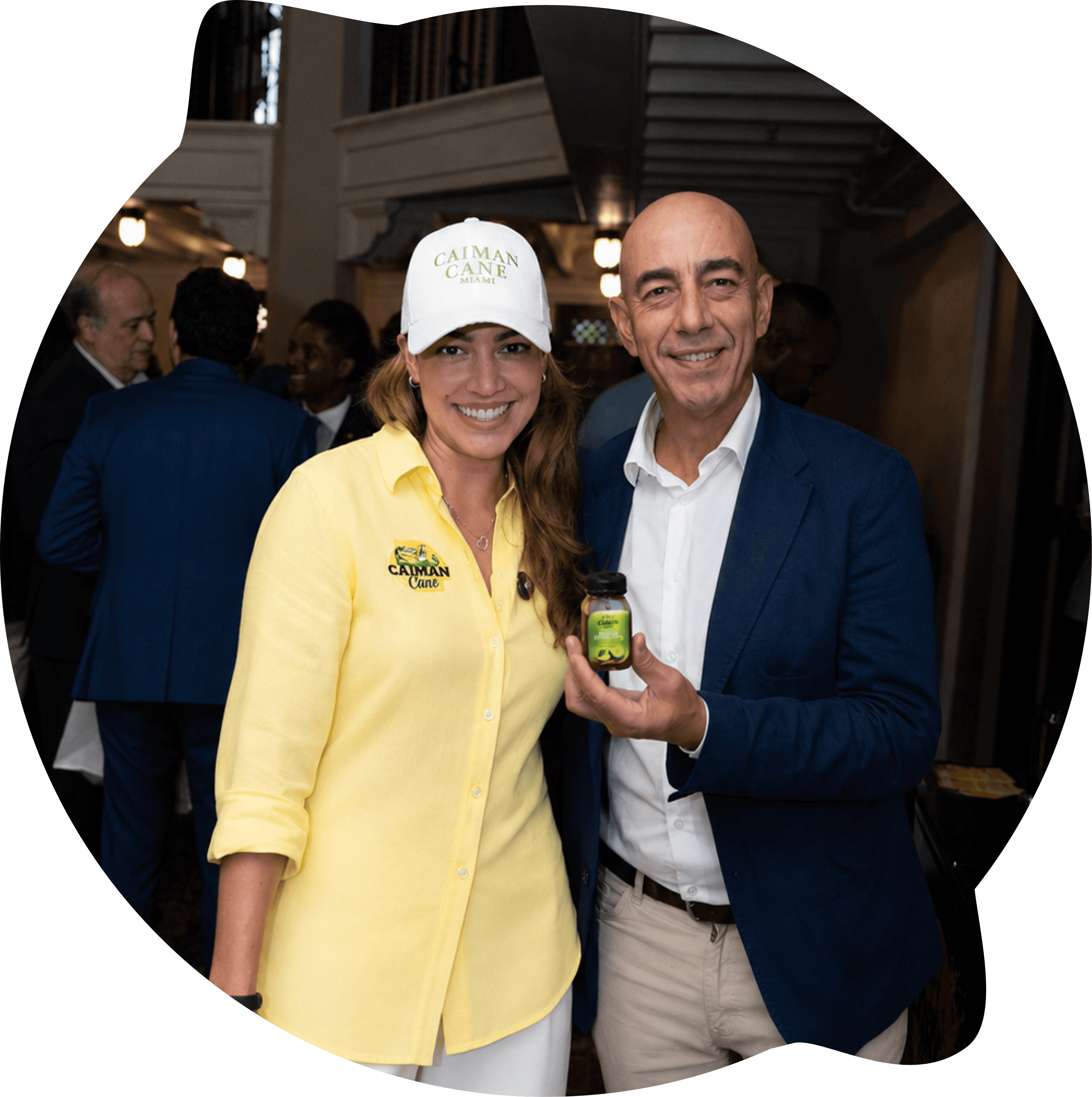 CEO de Caimán Cane, Yesireth, junto a un asistente en un evento, sosteniendo una bebida de 4 oz de limonada con caña de azúcar