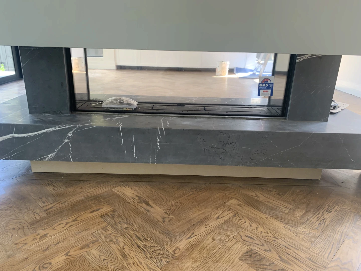 Black natural stone fireplace hearth detail with polished surface and modern timber floor setting.