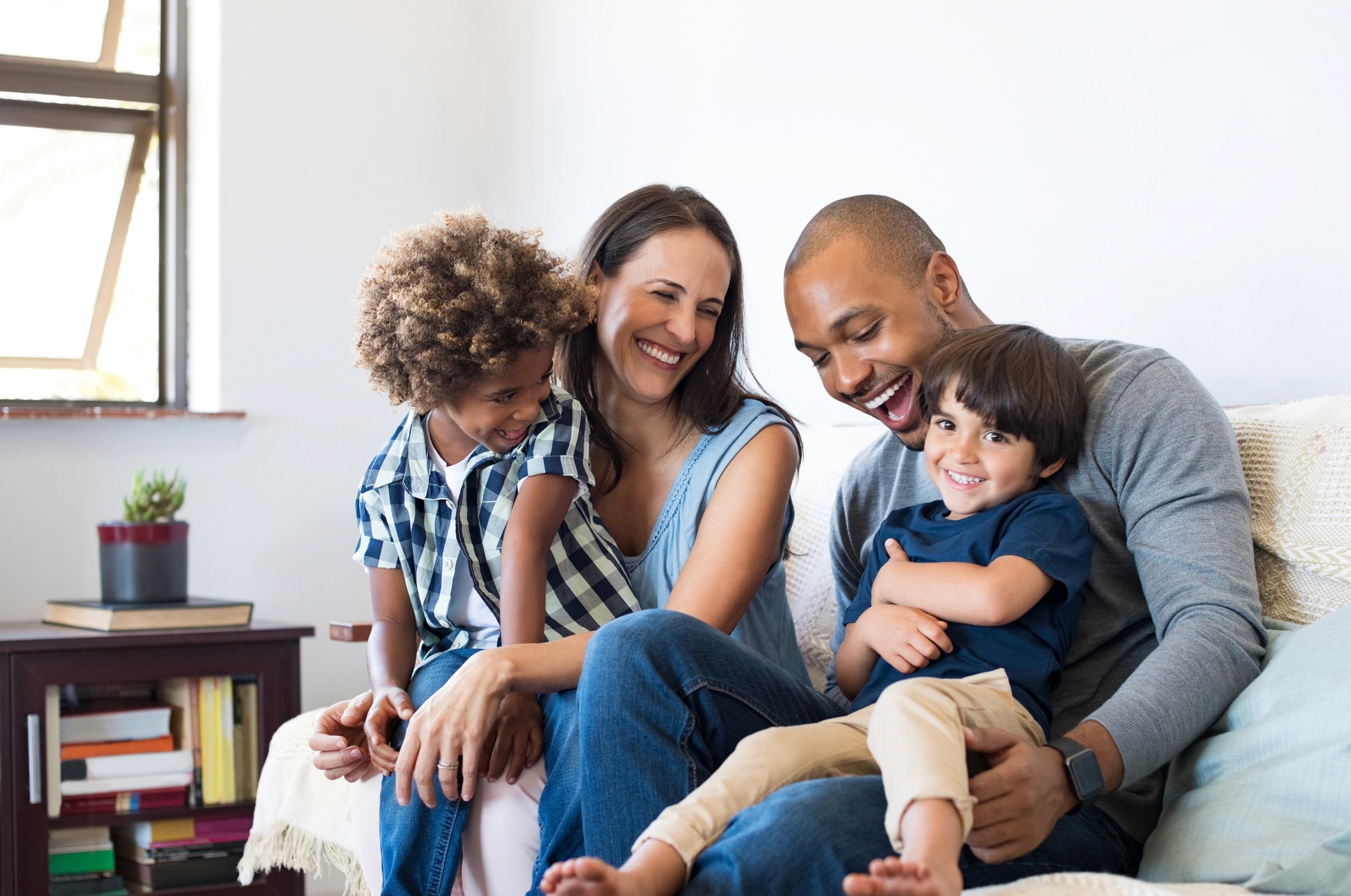 Familie of Colour lachend auf Sofa