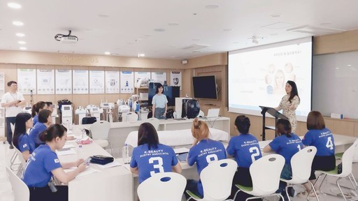 A team meeting with a man giving a presentation, surrounded by colleagues with laptops and gifts on the table.
