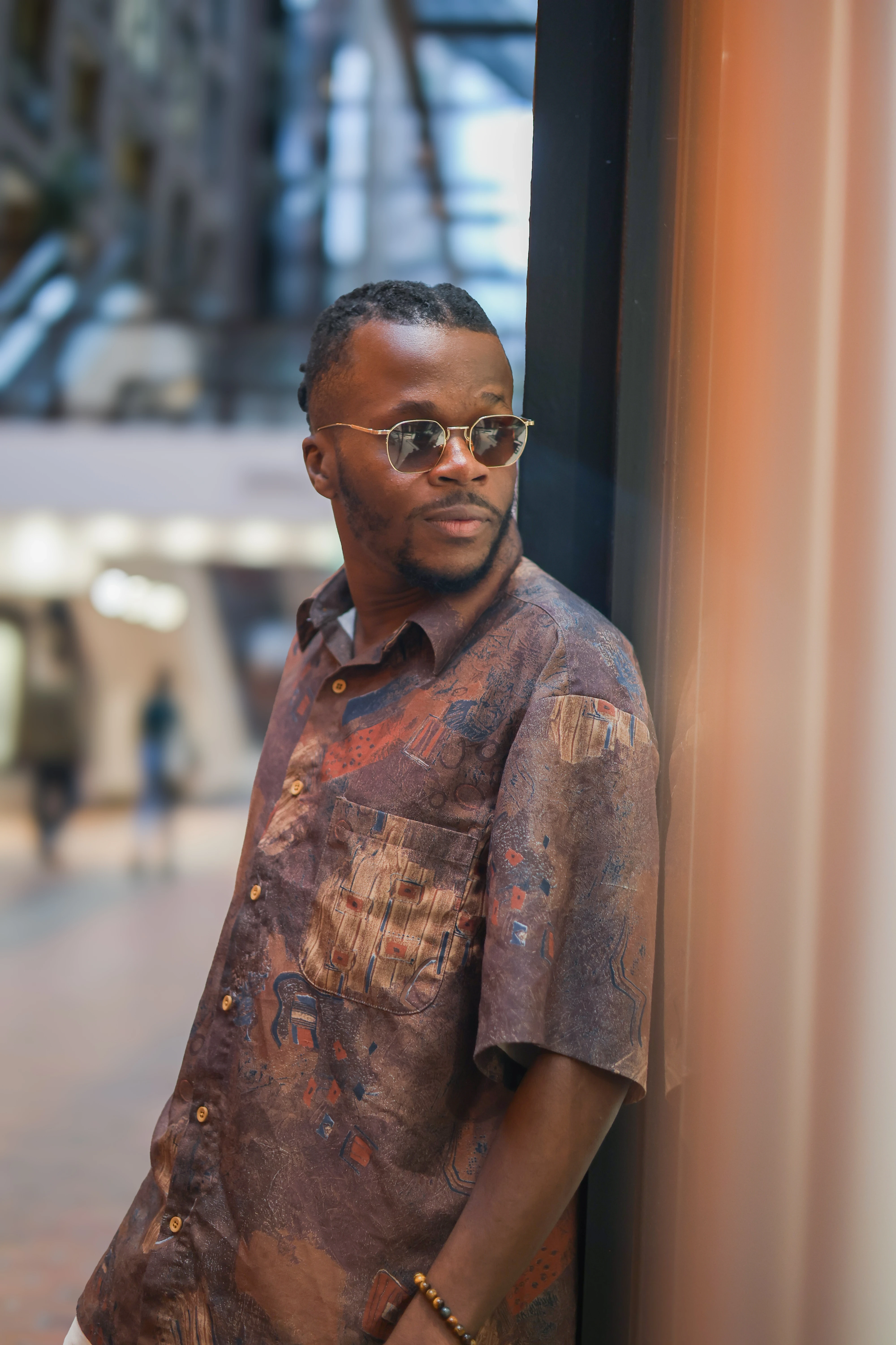 Model gazing at a store window with their reflection softly visible in the glass, framed by Montreal's urban streetscape