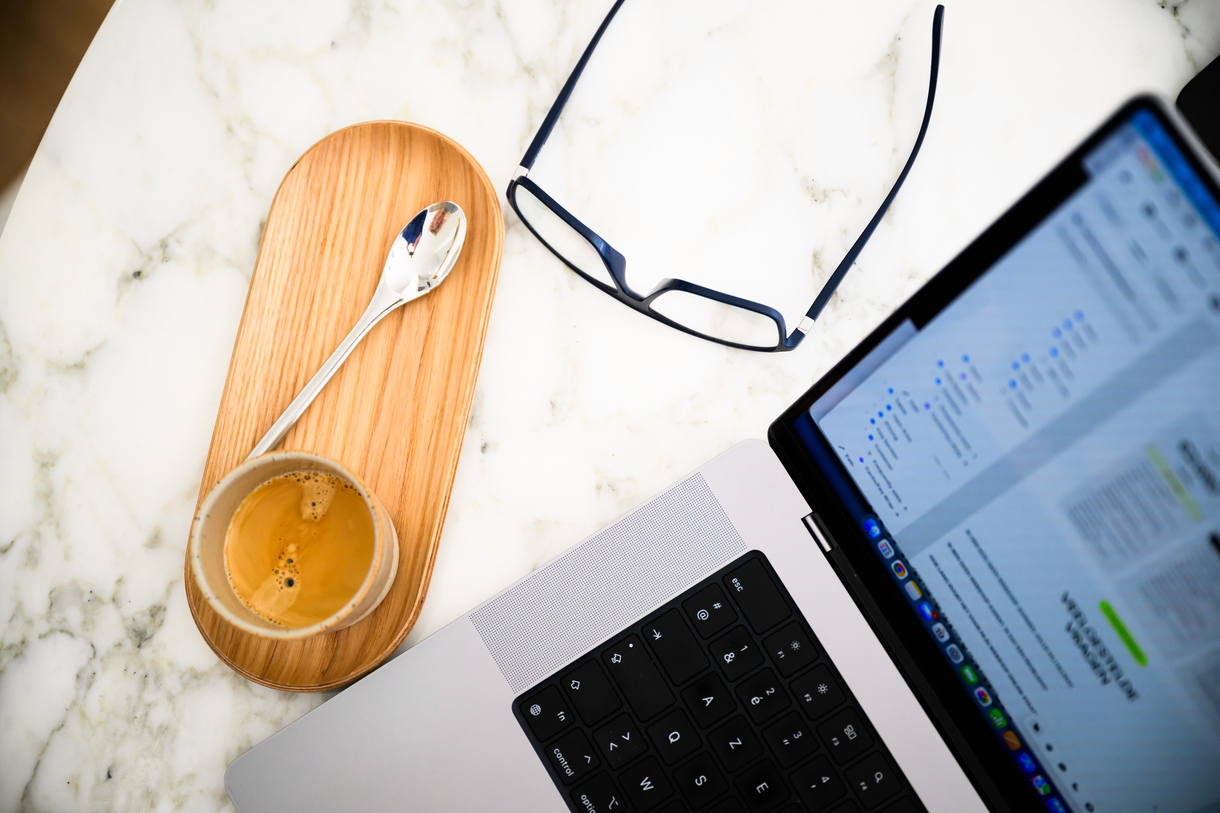 Bovenaanzicht marmeren tafel met laptop bril en koffie