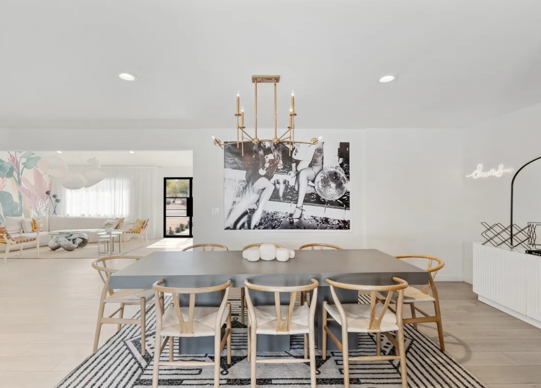 Close-up of a warm living space featuring a stone fireplace, a burnt orange accent chair with a striped pillow, a woven rug, and built-in shelves with decorative items