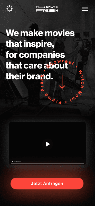 Mobile Ansicht der Startseite von Frame Fresh, einer Filmproduktionsagentur. Der Text lautet: “We make movies that inspire, for companies that care about their brand.” Ein kreisförmiger Text um einen Pfeil fordert dazu auf, das Showreel anzusehen. Darunter befindet sich ein Video-Thumbnail und eine rote Schaltfläche mit der Aufschrift “Jetzt Anfragen”