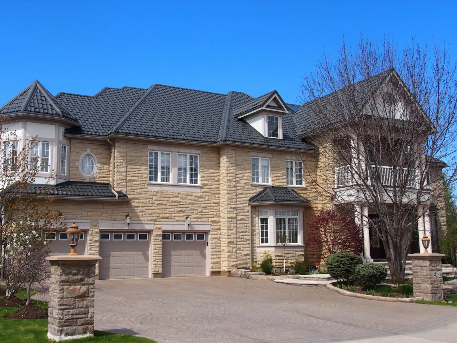 Tuiles métalliques noires sur maison de prestige avec tourelle et triple garage