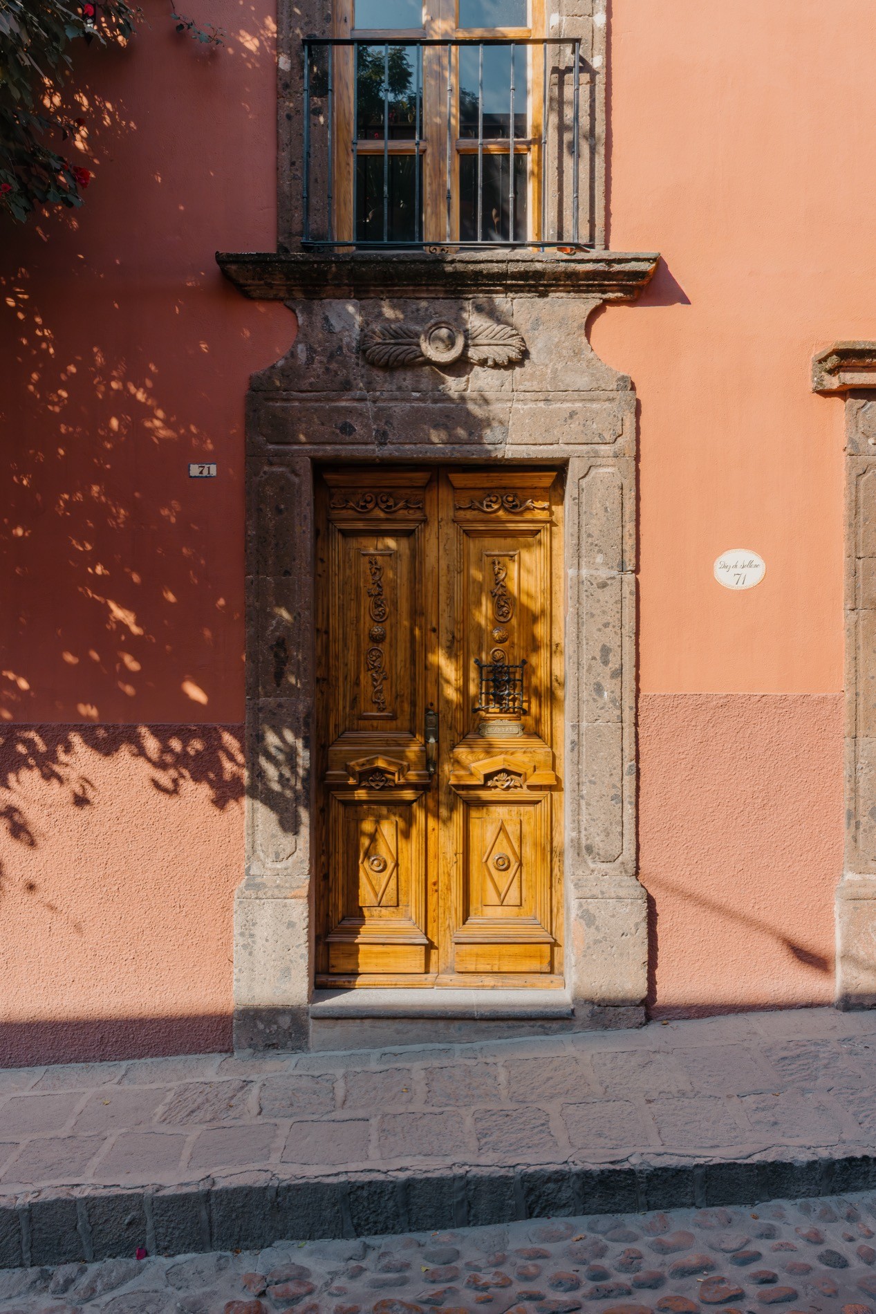 La Residencia San Miguel carved street door with stone frame on cobblestone street