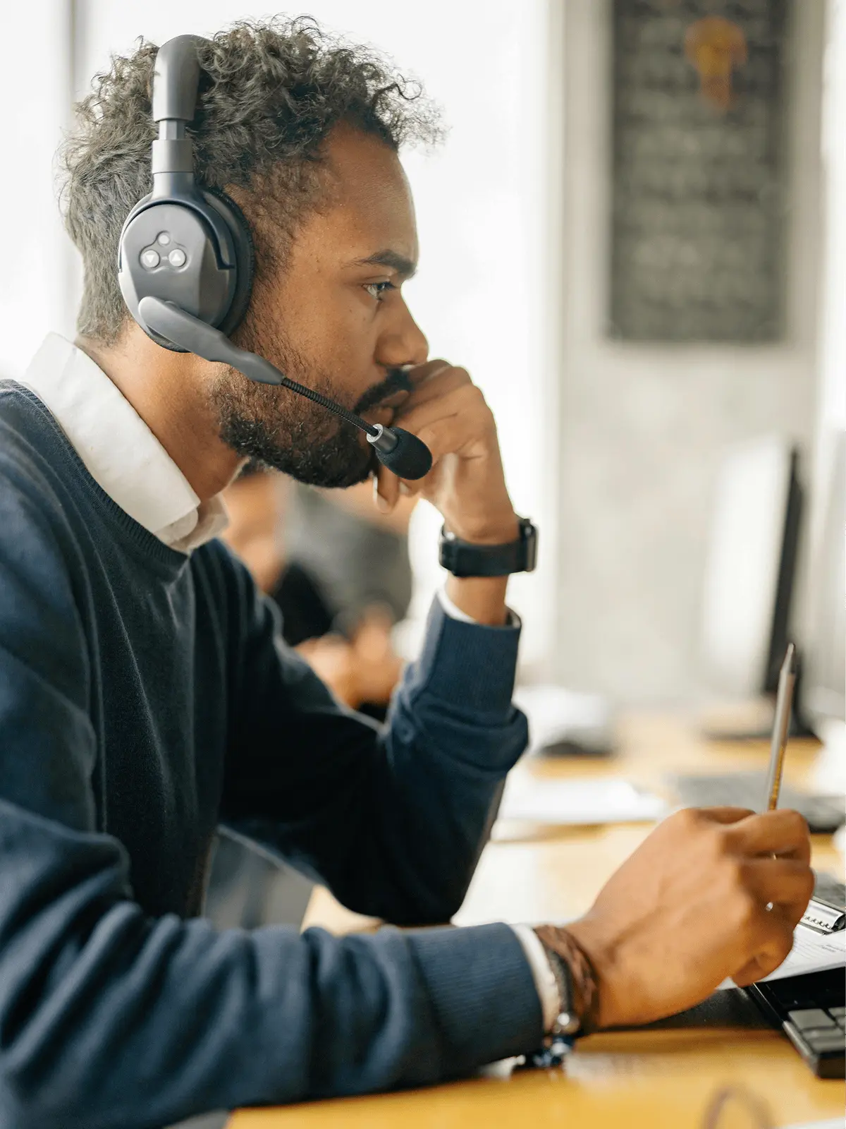 Support engineer wearing a headset at a workstation.