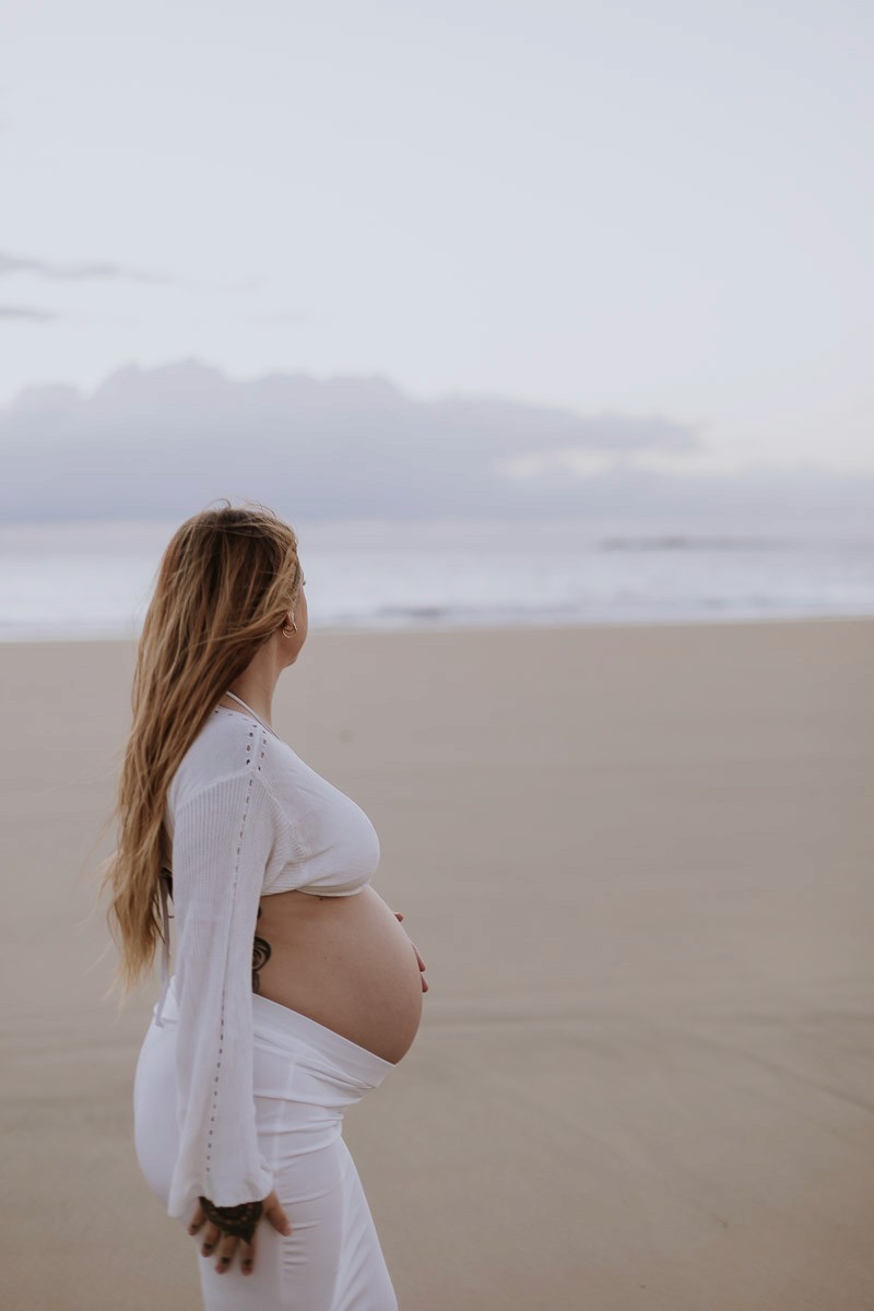 Pregnant woman walking along the beach during a maternity photoshoot in Mackay