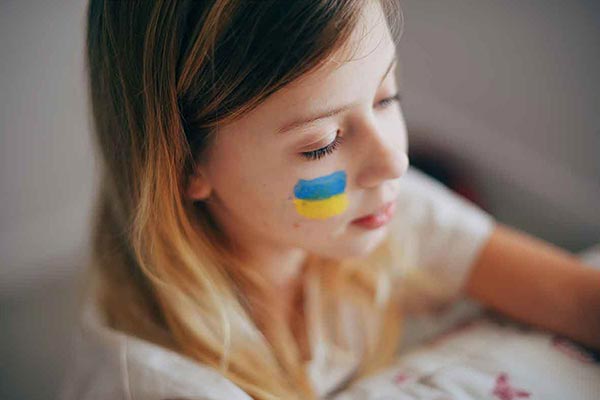 Дівчинка-переселенка з символом України