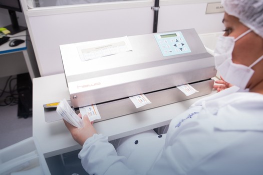 Colaboradora realizando selamento de envelope de sutura cirúrgica