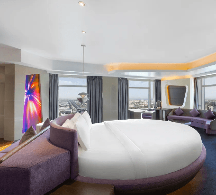 Pet-friendly hotel room at Curio V Hotel Dubai featuring a modern circular bed and city views.
