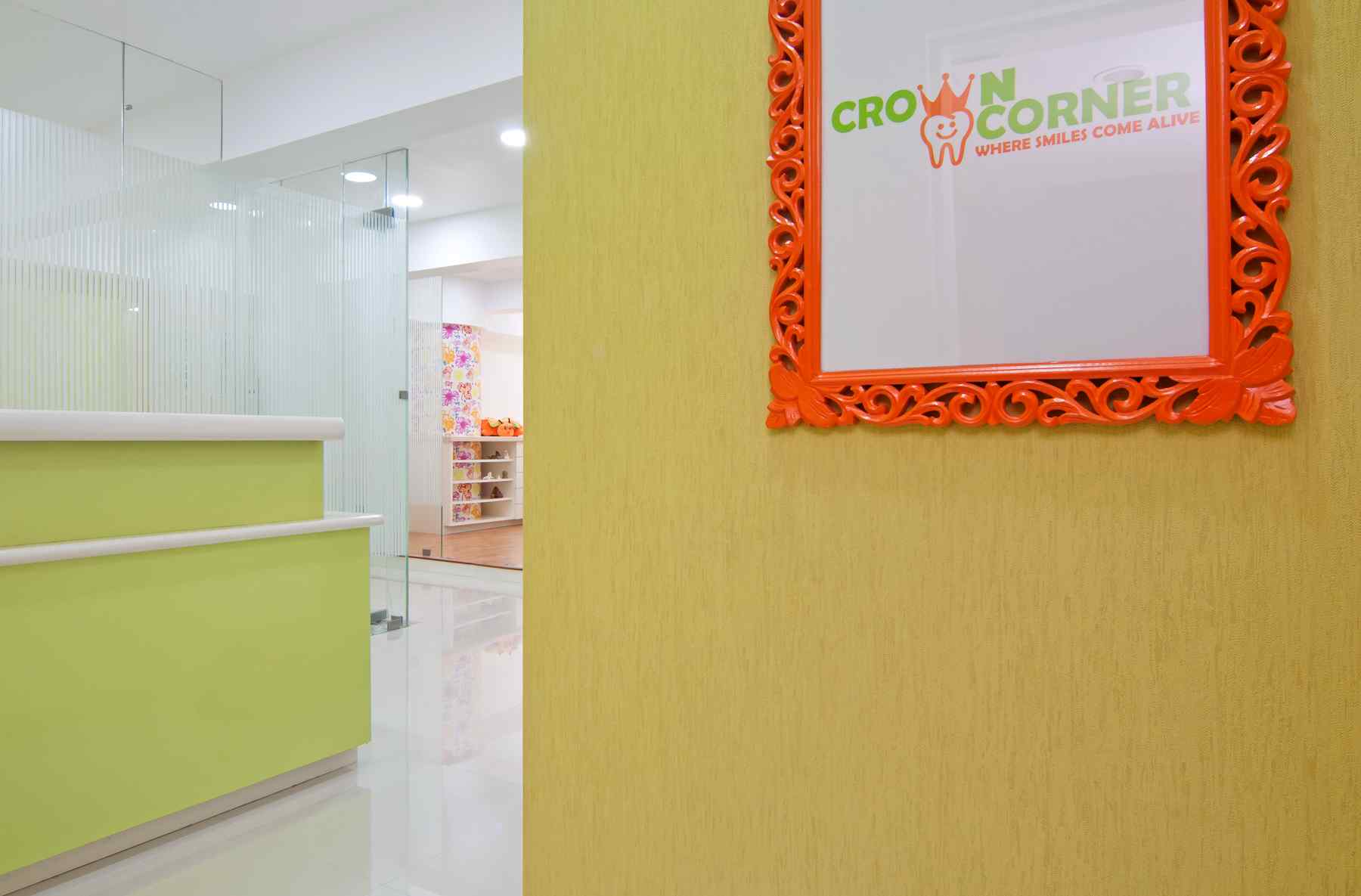 Nature-inspired preschool entrance with sculptural tree partitions and suspended green leaf ceiling panels.