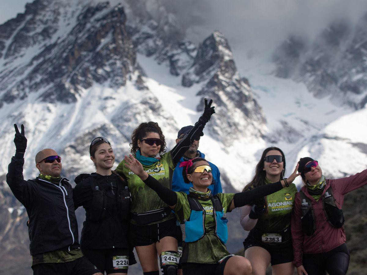 Three people sitting on a couch in a room looking at mobile devices
