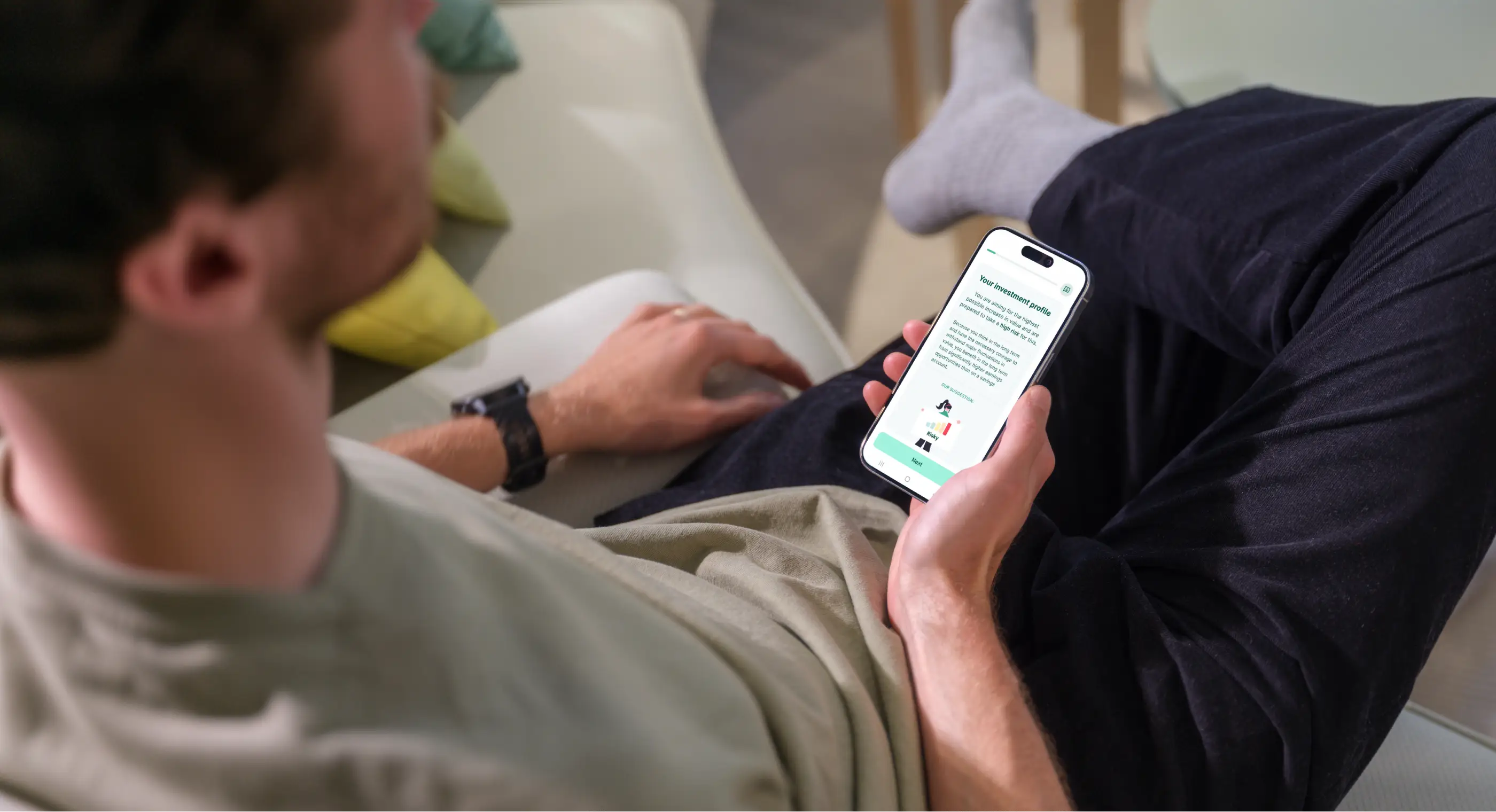 A man holds a smartphone displaying the findependent investment app.