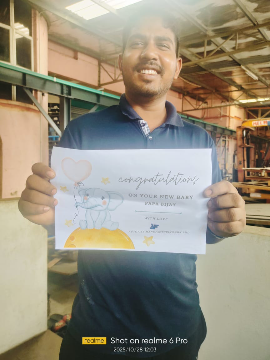 Autofill employee Mr. Bijay holding a new baby congratulatory note from the team, showcasing employee appreciation.