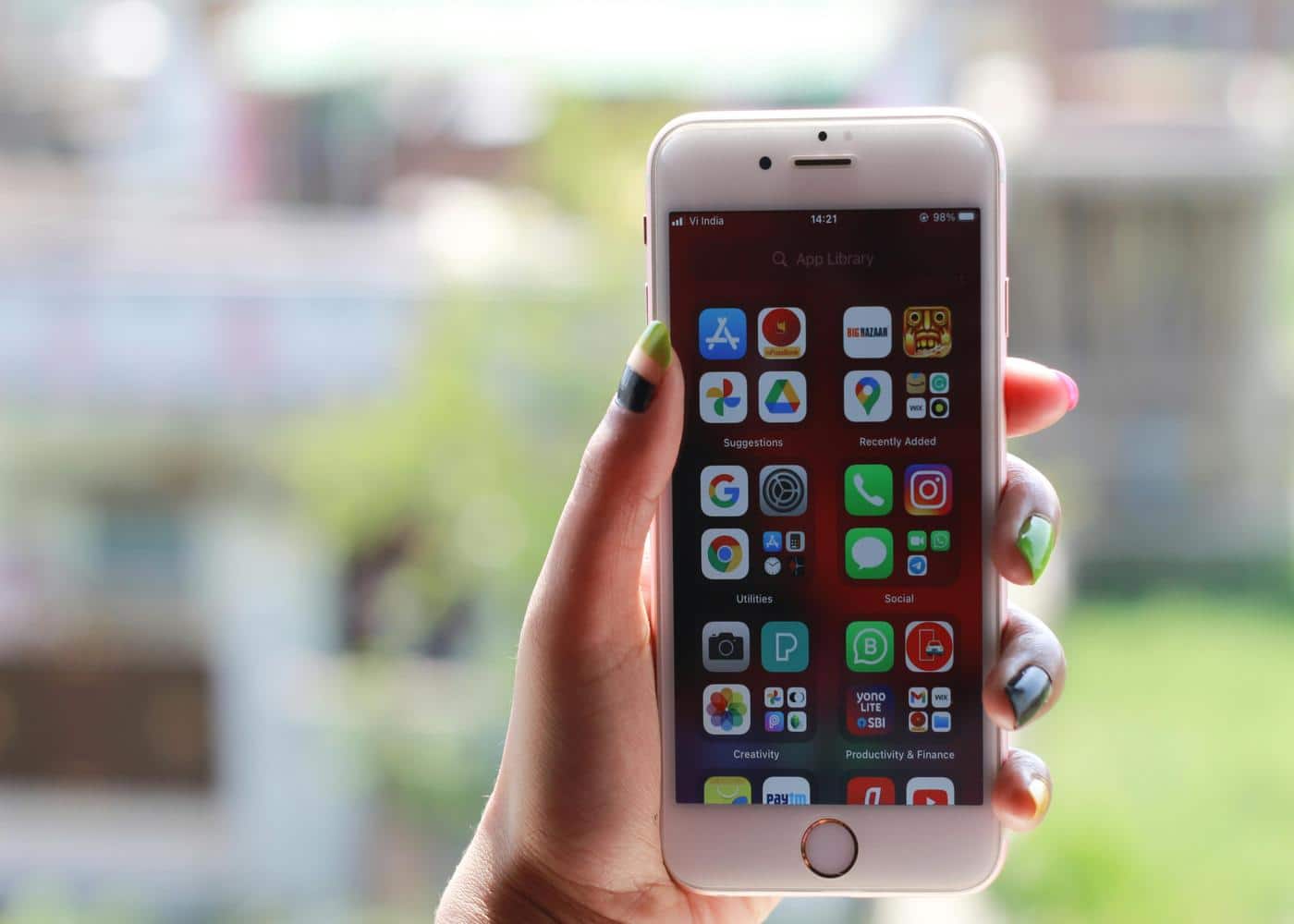 Person holding iPhone showing applications on phone