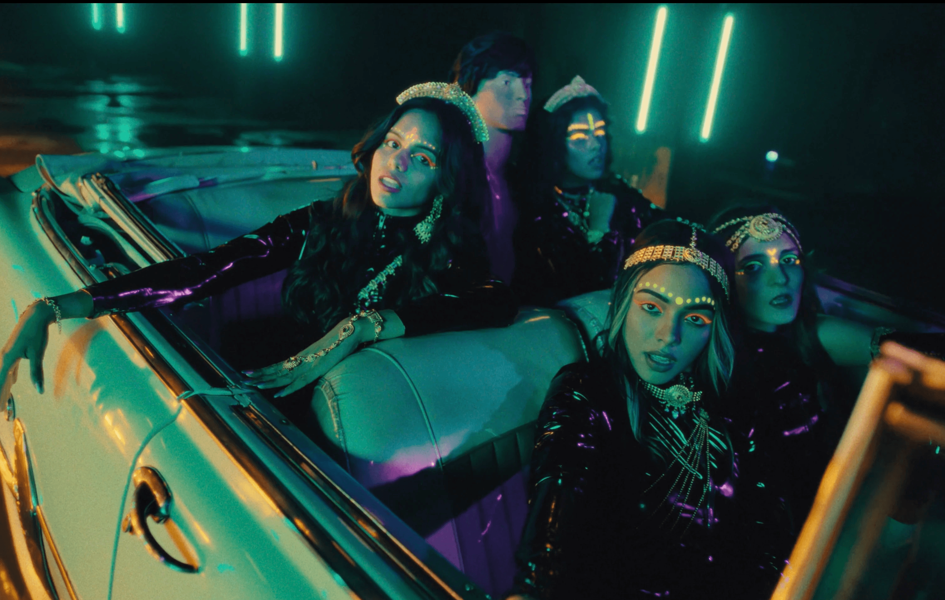 4 women sitting in a vintage car