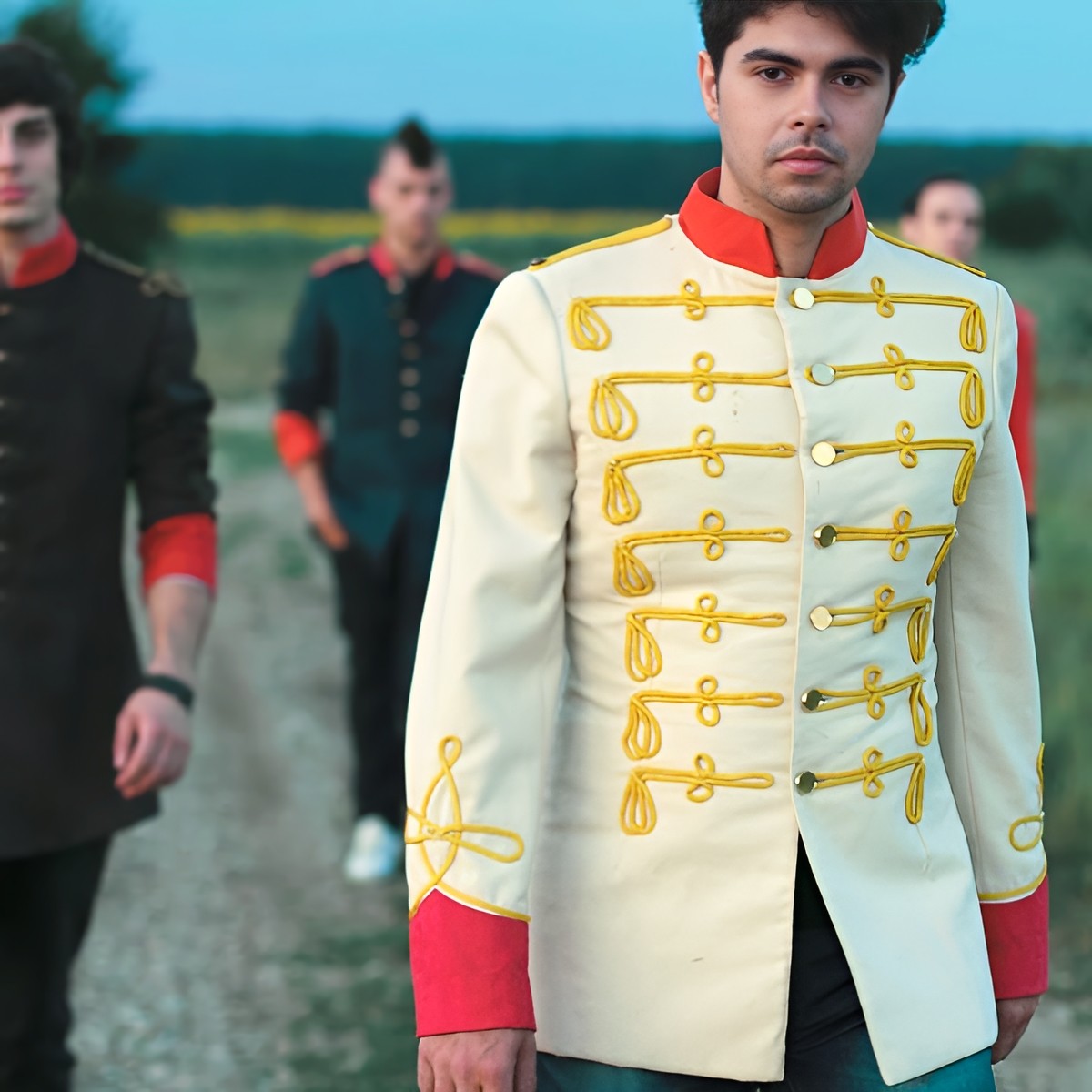 Plastik Charm’s members wear vintage military-inspired jackets while walking outdoors at sunset.