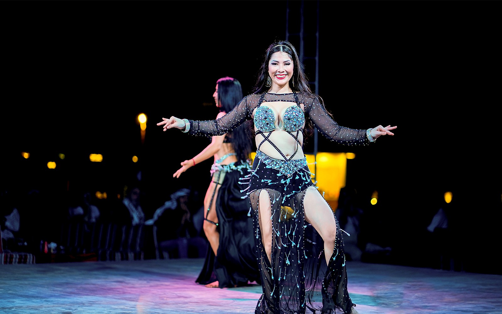 Woman dancing at Dubai desert safari experience.