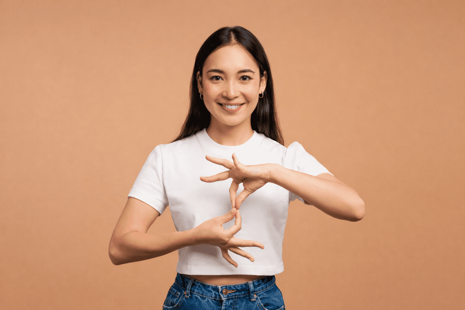 A lady interepreting a message for students who are hard of hearing using sign language, via hand gestures