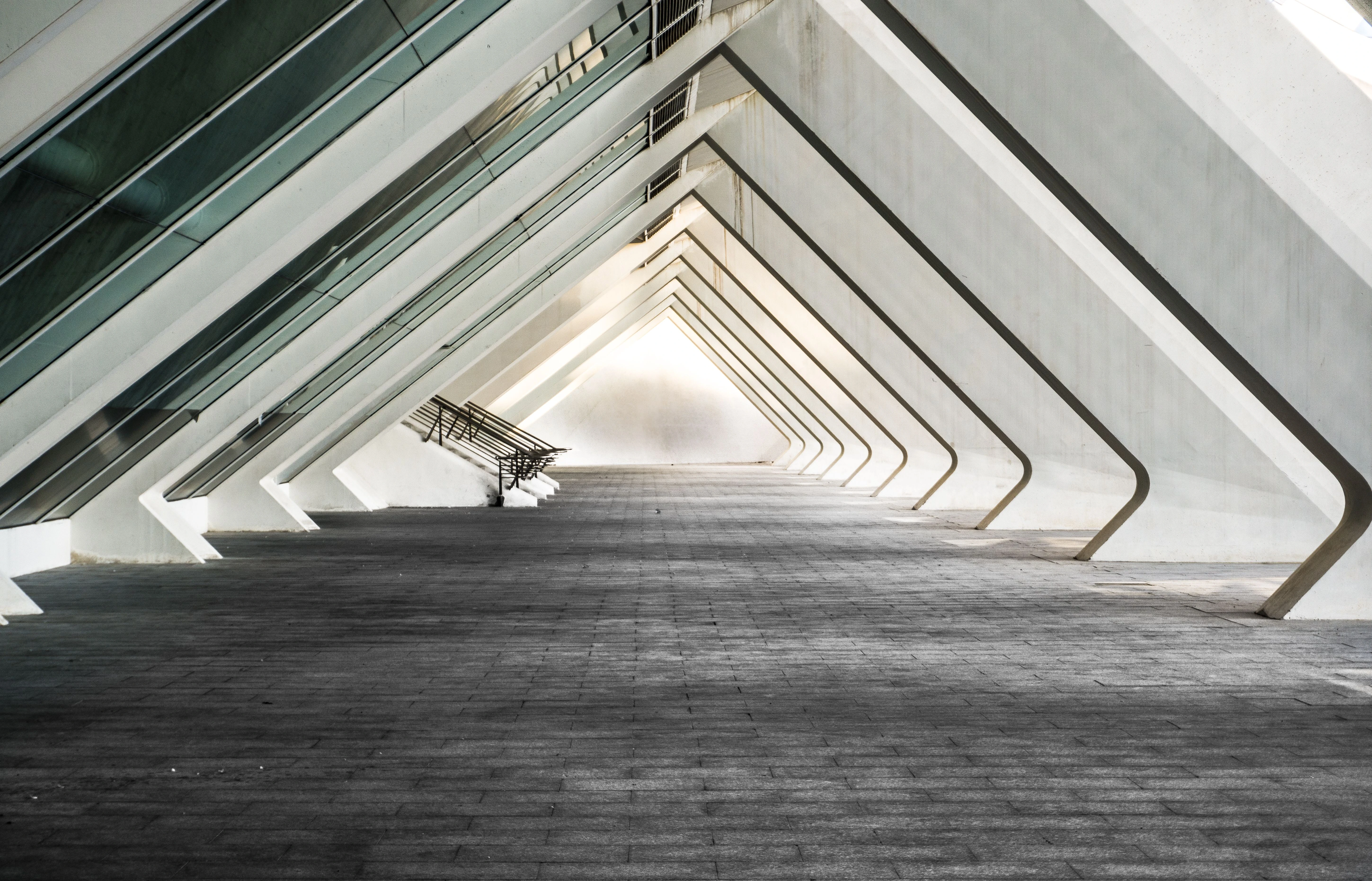 Modern hallway corridor framed by repeated illuminated geometric arches.