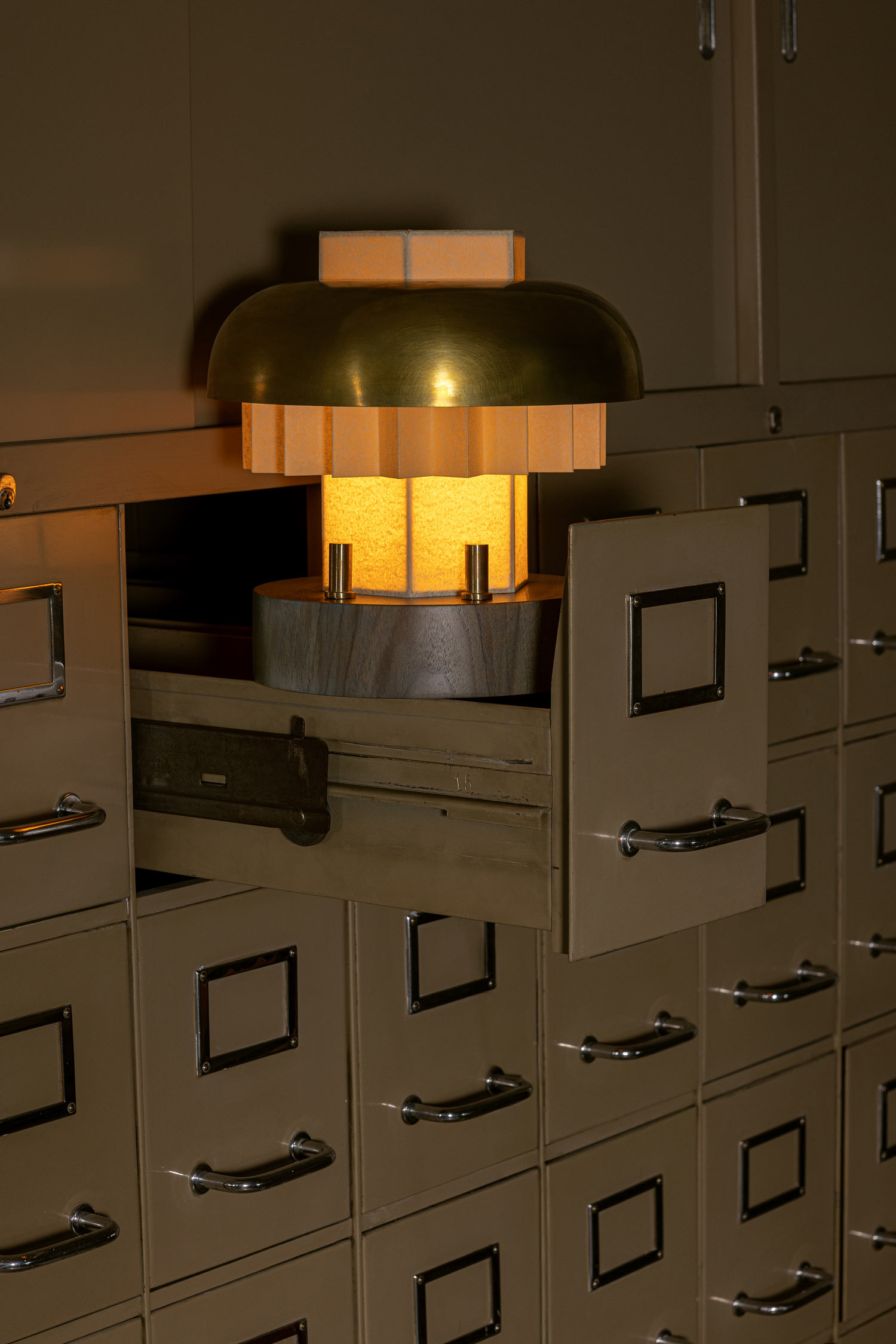 Emilie table lamp styled in space emphasizing geometric shade and warm illumination by Jiri Krejcirik