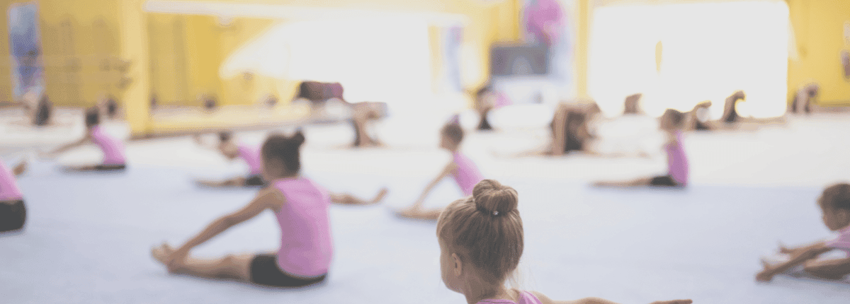 15 or so girls doing gymnastics warmup in our main gym